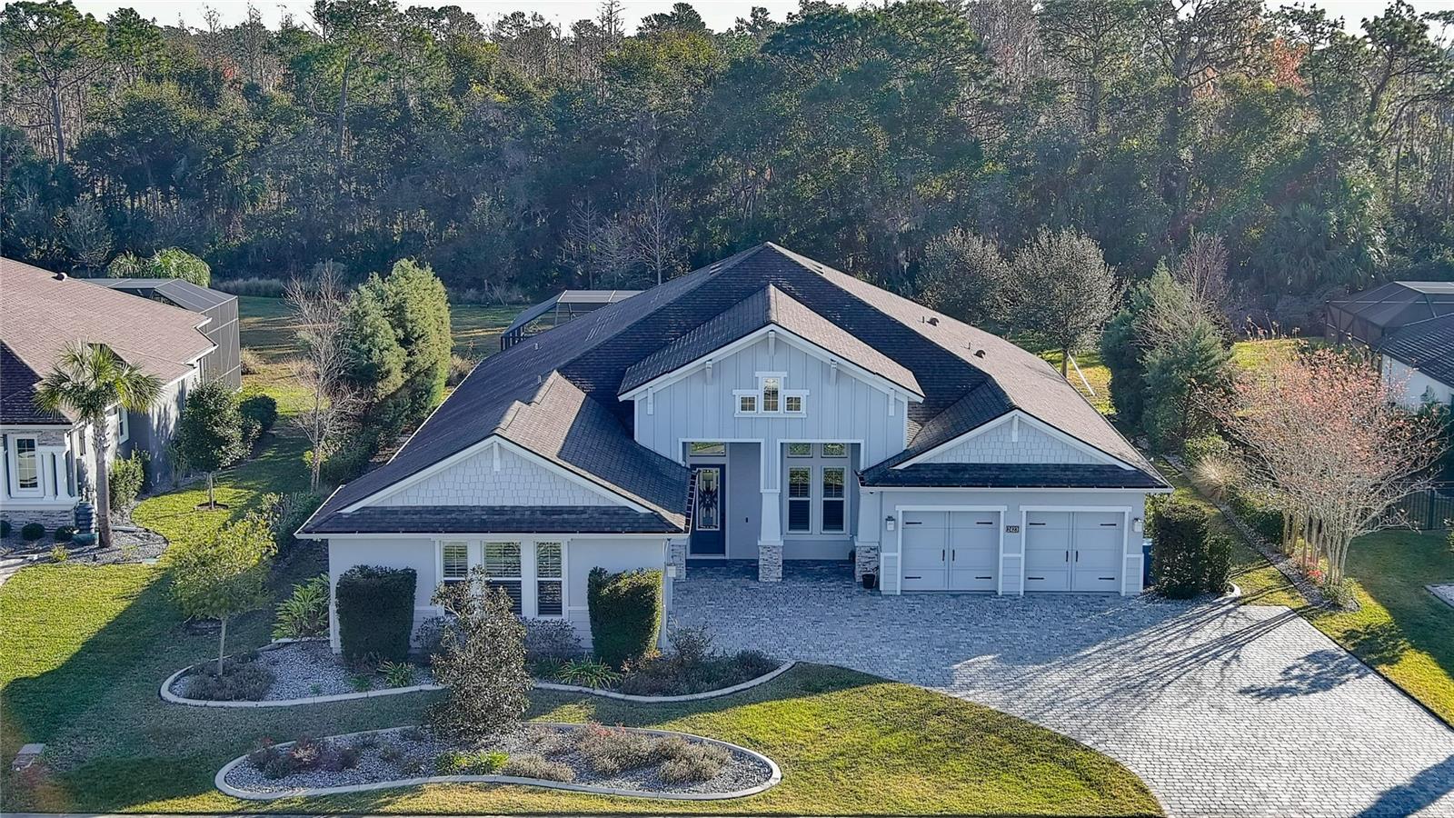 One or more photo(s) has been virtually staged. Furniture only has been staged. Exquisite one-story home with luxurious features and private resort-like amenities. This exceptional one-story, three-car garage home seamlessly blends upscale finishes with a sense of comfort and sophistication. The open-concept layout, meticulously designed and appointed, features four spacious bedrooms, office (5th bedroom) and three-and-a-half baths. The great room is highlighted by a shiplap-accented wall, complete with a fireplace that creates a welcoming ambiance and an expansive wall of windows that invite natural light to fill the space. At the heart of the home, the chef's kitchen offers an abundance of custom cabinetry, a large center island, quartz countertops and premium stainless steel appliances — creating an ideal space for family gatherings and culinary endeavors. The adjacent dining room offers a seamless transition for entertaining. The luxurious owner's suite is bathed in natural light and showcases an intricate double-tray ceiling with double doors that open to a spa-like bath. The striking oval soaking tub, illuminated by a dazzling chandelier and framed by a waterfall-tiled feature wall, serves as the focal point of the room. The bath also includes a spacious custom shower, double vanities, a separate water closet and an impressive walk-in closet that leads directly into the conveniently located laundry room. Throughout the home, high-end flooring flows seamlessly from room to room with no transitions, enhancing the cohesive and luxurious feel of the space. Fiber and cable are installed, ensuring modern connectivity throughout. Designed with entertaining in mind, the lanai is an extraordinary outdoor living space, featuring a marine-grade outdoor kitchen complete with a grill, side burner, vent hood with dual fans, refrigerator, sink with disposal and ample countertop space. Relax in the serene outdoor setting as you enjoy the cascading waterfall from the heated spa, which flows into the pool below. The entire space is enhanced by remote-controlled lighting, an outdoor shower and tall landscaped plantings that offer privacy and seclusion. The home backs to a peaceful preserve, further adding to the tranquil ambiance. Additional highlights include durable epoxy-coated garage floors, a hybrid water heater, a Grundfos recirculating instant hot water pump and ceiling speakers for surround sound in both the living room and lanai. The home is also equipped with Eufy floodlights, IP cameras and automated controlled lighting in the halls, baths and garage for added convenience and security. A private well, installed during construction, serves the home's automated irrigation system and can also be utilized for other outdoor needs. Just down the street from Brown's Landing is the Spruce Creek Fly-In Community. Its Country Club offers memberships that are open to the public—you don’t have to be a resident of the community to join. Enjoy access to exceptional golf, dining, and social amenities in one of the most unique private airpark communities in the country. This is truly a private, resort-like retreat an unparalleled combination of elegance, functionality and comfort. Bullet points of additional upgrades are available.