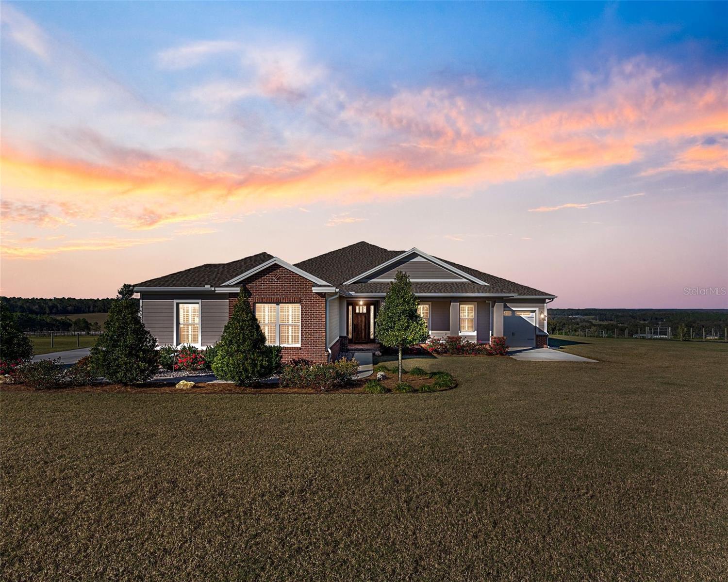**50K PRICE DROP** Come see the hills and valleys of Northeast Pasco County! Some of the highest elevations found in Florida are right here. The view from this property is simply stunning! This owner-built custom home that sits atop a 3-Acre parcel is just as impressive as the view around it! The 3 bedroom, 3 bath, and office with a view residence stands above others in every way. From the perfectly stained and sealed Cypress Ceiling and 2-Piece Crown Molding to the oversized foundation underlying the entire structure that was poured with 3500 psi concrete, exudes lasting quality and undeniable beauty. This house required 18 months to build and became a home in June 2019, when the owner moved in. Remember, quality takes time. You simply will not find a better built home. As you study the pictures you will notice the Hickory flooring throughout. They are stained to complement the ceiling and crown, but not to match it. In turn, showcasing each. The addition of an 18” x 18” x ½” Travertine Stone set with 1/16” grout line was the finishing touch to a beautiful floor. As you continue to look through, you will notice the attractive Poplar Trim around the windows, doors, columns, and floor. All painstakingly installed for precise fit and finish. The columns and beams at the entry are bold and lead guests to the living and entertaining area of the home. There you overlook the attractive and spacious covered porch, and of course, that view of the hills. As you continue your tour, you will notice the 8’ tall-solid core doors installed throughout. Next, the kitchen has been fitted with an impressive array of Decora Cabinets, with solid Cherry fronts, doors, and drawers. The Steel Grey Granite transitions to the Tumbled Travertine backsplash, and produces an inviting area for cooking and entertaining. The JennAir Pro-Series appliances finish the look and proclaim quality. The Air Conditioning and Heat are provided by two Carrier Infinity Series units (their best residential units). They are reliable and precise. PGT Hurricane Rated windows provide safety for the home as well as an insulation value that keeps the electric bill consistently lower than average for this 3000sqft.-living/5000sqft-under roof home. The residence has a dedicated A/V Room in the main garage, where all equipment is housed, and all cables terminate. All cables run through the attic to each room, and everything is controlled by iPad. The system will accommodate anything you want to add to the system. Also, a professional security camera system is installed and operates from said AV Room. The exterior of the home consists of Block, Hardie Siding, Hardie Soffit, Hardie Facia, Hardie Ceilings at front porch and back porch, and Hardie Trim around windows and doors. The 30’x 36’ Barn has power and water. It was built for equipment storage and has an 8’x15’ tool storage room, poured concrete throughout and a 10.5’h x 11’w Hurricane Rated Rolling Overhead Door. Last but not least, there’s the small town of Dade City just down the road. Dade City is known for its Kumquat Festival, Christmas Festival, and some of the best ‘one-off’ restaurants you’ll ever find. This small town is also brimming with unique boutiques and antique shops. Schedule your showing today!