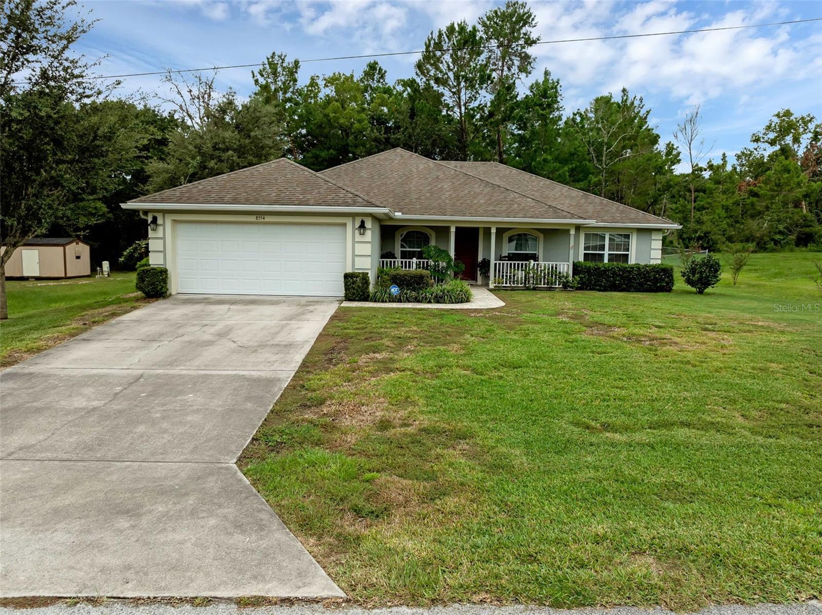 Lovely 3-bedroom, 2-bathroom home located in Orange Blossom Hills North of The Villages in Summerfield. A welcoming front porch invites you to a pristinely maintained interior with a split floor plan. Attractive, wood-looking tile floors in all living areas add to the charm. A spacious kitchen boasts stainless steel appliances, a pantry, snack bar and lots of cabinets and countertop space. An adjacent breakfast nook overlooks the fenced-in back yard. The large family room is separate from a cozier living room making this a great place for tv time while others enjoy quiet conversation. The primary suite has two roomy closets and dual vanities not to mention a huge walk-in shower. Outside a big back yard shed with electric and A/C offers handy and comfortable workspace. All this home needs are your personal touches to make it your own. Just a short drive to all the amenities of The Villages, restaurants and shopping.