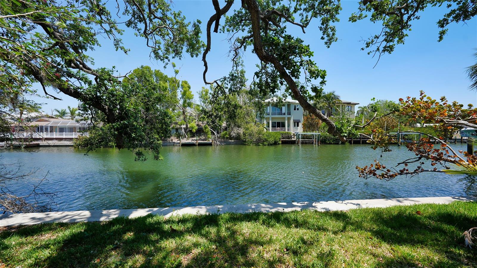 TWO BUILDABLE LOTS! Incredible opportunity to build your dream home—or two—on Siesta Key’s iconic Grand Canal. This exceptional waterfront property is located on picturesque Oxford Street, a charming canopy road with direct boating access to Sarasota Bay, the Intracoastal Waterway, and the Gulf of Mexico. Features include an updated seawall cap, a rare covered boat slip and lush, tropical vegetation. A storm-damaged home remains on-site; boundary survey, topographical survey, and a demolition estimate are available. Ideally situated just minutes from the powdery white sands of world-renowned Siesta Key Beach and the energetic Siesta Key Village, where you can stroll through charming boutiques, restaurants that offer fresh seafood, sip cocktails at lively beach bars, and soak up the island’s carefree, tropical spirit. Nestled amid lush tropical vegetation, this waterfront property invites you to embrace a luxurious island lifestyle. Enjoy boating, kayaking, paddleboarding, and fishing right from your backyard, surrounded by the natural beauty of one of Florida’s most sought-after coastal communities. While offering peaceful island serenity, the property is also just moments from downtown Sarasota, where world-class cultural attractions, gourmet dining, and vibrant entertainment await. It’s the ideal blend of relaxed coastal living and city convenience.