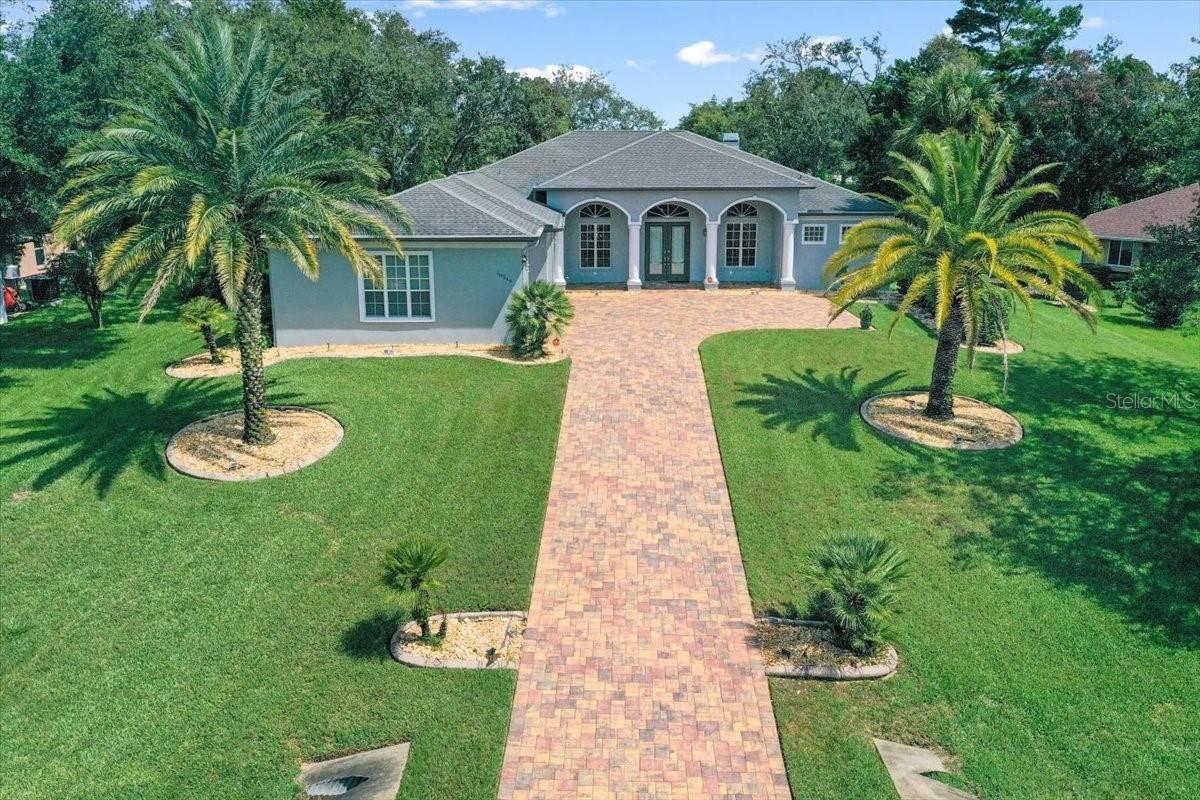 GATED LUXURY in THE ENCLAVE of WOODLAND WATERS - SHUFFLEBOARD COURT & HUGE PATIO! Welcome to 10249 FEATHER RIDGE DRIVE, a stunning 3-BEDROOM + OFFICE home on a large HALF-ACRE LOT with 2,364 SQ FT LIVING and an impressive 4,137 SQ FT UNDER ROOF—including a MASSIVE 880 SQ FT 3-CAR SIDE-ENTRY GARAGE. Built in 2006 and METICULOUSLY MAINTAINED, this home combines elegance, comfort, and FUN in one beautiful package. From the moment you arrive, you'll notice the BRICK PAVER DRIVEWAY, double front door entry and freshly PAINTED exterior (2025). Recent updates include a NEW AC SYSTEM (2022), NEW ROOF TO BE INSTALLED, and NEW HOT WATER HEATER (2024). Inside, you'll find TILE FLOORING THROUGHOUT, a WOOD-BURNING FIREPLACE in the GREAT ROOM, and a KITCHEN WITH NEWER APPLIANCES including a wall oven and cooktop. The primary suite features HIS & HERS CLOSETS WITH BUILT-INS, plus a spa-like bath with a GARDEN TUB and WALK-IN SHOWER. The HUGE LAUNDRY ROOM even includes a HALF BATH for added convenience. Other upgrades? A GENERAC WHOLE-HOUSE GENERATOR, SECURITY SYSTEM, CENTRAL VACUUM SYSTEM, and SPRINKLER SYSTEM WITH IRRIGATION WELL to keep the landscaping lush. But let's talk about the BACKYARD—it's a PRIVATE OASIS with MATURE LANDSCAPING, a CUSTOM-MADE PROFESSIONAL SHUFFLEBOARD COURT (HELLO, ENDLESS TOURNAMENTS!), and a SPACIOUS PAVER PATIO perfect for gatherings. Located in the GATED ENCLAVE OF WOODLAND WATERS in WEEKI WACHEE, you'll be just minutes from WEEKI WACHEE SPRINGS STATE PARK, where the mermaids swim, and close to HERNANDO BEACH, PINE ISLAND, and the SUNCOAST PARKWAY for an easy drive to TAMPA in under an hour. BRING YOUR CUE STICK AND YOUR SHUFFLEBOARD SKILLS—THIS HOME IS READY FOR YOU! NO CDD FEES, NO FLOOD ZONE AND LOW HOA FEES.