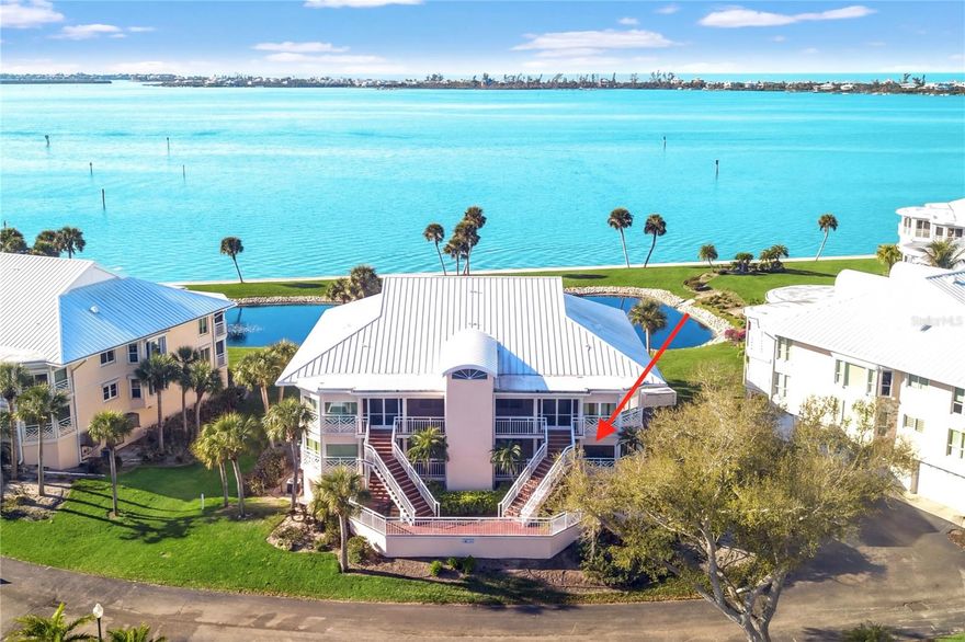 One or more photo(s) has been virtually staged. Experience refined coastal living at Placida Harbour Club in this beautifully reimagined, one-level residence offering 2,103 square feet of living space. Completely updated and redesigned to include 3 bedrooms and 2.5 bathrooms, this stunning condominium captures sweeping panoramic views of Placida Harbor and the Intracoastal Waterway from nearly every angle.

Inside, wood-look porcelain tile flows seamlessly throughout, complemented by smooth drywall finishes, LED lighting, and impact glass windows and doors with additional hurricane shutters for peace of mind. The chef’s kitchen is both elegant and functional, showcasing GE stainless steel appliances, quartz countertops, solid wood cabinetry, and generous prep space, all perfectly positioned to enjoy tranquil water views while cooking or entertaining.

The redesigned primary suite layout enhances both comfort and functionality, creating immense closet space rarely found in condominium living. The spacious primary bathroom offers dual vanities, refined finishes, and a large walk-in shower.

A custom built-in bar with integrated refrigerator and freezer drawers adds a sophisticated touch for hosting, while the fully remodeled bathrooms reflect a clean, contemporary aesthetic. Step onto the screened lanai and savor the waterfront breeze, enhanced by electric roll-down hurricane screens for protected, year-round enjoyment.

Practicality meets luxury with elevator access, a new standing seam metal roof (2023), and a two-car tandem garage paired with an oversized private storage room—an exceptional offering in condominium living.

Beyond the residence, Placida Harbour Club delivers a dynamic waterfront lifestyle. Residents enjoy multiple clubhouses, heated swimming pools, a well-equipped fitness facility, tennis and pickleball courts, a deep-water marina with kayak launch, scenic shoreline walking paths, and private ferry service to the unspoiled beaches of Little Gasparilla Island.

Unit 2602 presents a rare opportunity to own a meticulously upgraded waterfront retreat where thoughtful design, luxury finishes, and panoramic views converge.