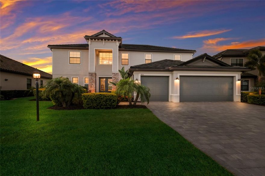 Experience the pinnacle of Florida luxury in this masterfully upgraded Wynwood floor plan, the crown jewel of the Estate Collection in the gated enclave of Lorraine Lakes. This 4,000+ square-foot sanctuary boasts a sprawling five-bedroom, 4.5-bath layout featuring porcelain plank tile throughout the main living areas and designer-planned lighting, including custom chandeliers in the kitchen, dining room, office, and foyer. The gourmet kitchen showcases crisp white cabinetry, premium quartz countertops, a custom high-end tile backsplash, an upgraded stove vent, and a massive social island finished with custom shiplap. This elegance extends to the living room and the reimagined powder room, which features a high-end vanity, faucet, mirror, and custom shiplap. The home’s rare dual-owner-suite configuration is ideal for multi-generational living, offering a downstairs suite with a custom mirror and an upstairs primary retreat featuring custom wood beams and board and batten millwork. Both primary suites and the living room are elevated by custom drapery, while all four full bathrooms feature custom high-end tile and both primary showers are equipped with upgraded dual-head systems. The interior is completed by a private office with custom millwork, a spacious 21' x 20' bonus room, and three additional guest bedrooms. Outside, a 600-square-foot covered lanai with three upgraded fans overlooks tranquil lake views and a one-of-a-kind, 34-foot heated pool featuring waterfalls, a 12-person spa, and a massive sunledge. The grounds are a tropical paradise with palms and birds of paradise maintained by a custom Rain Bird irrigation system and professional spot lighting. Practical features include an upgraded large-capacity washer and dryer, speckled epoxy garage floors, and a Tesla car charger. Residents enjoy exclusive access to Lorraine Lakes’ resort-style restaurant, bar, fitness center, and sports courts—widely regarded as having some of the best amenities in all of Lakewood Ranch. This exceptional property is ideally located near top-rated schools and is just minutes from the area's best beaches, world-class shopping, and diverse dining