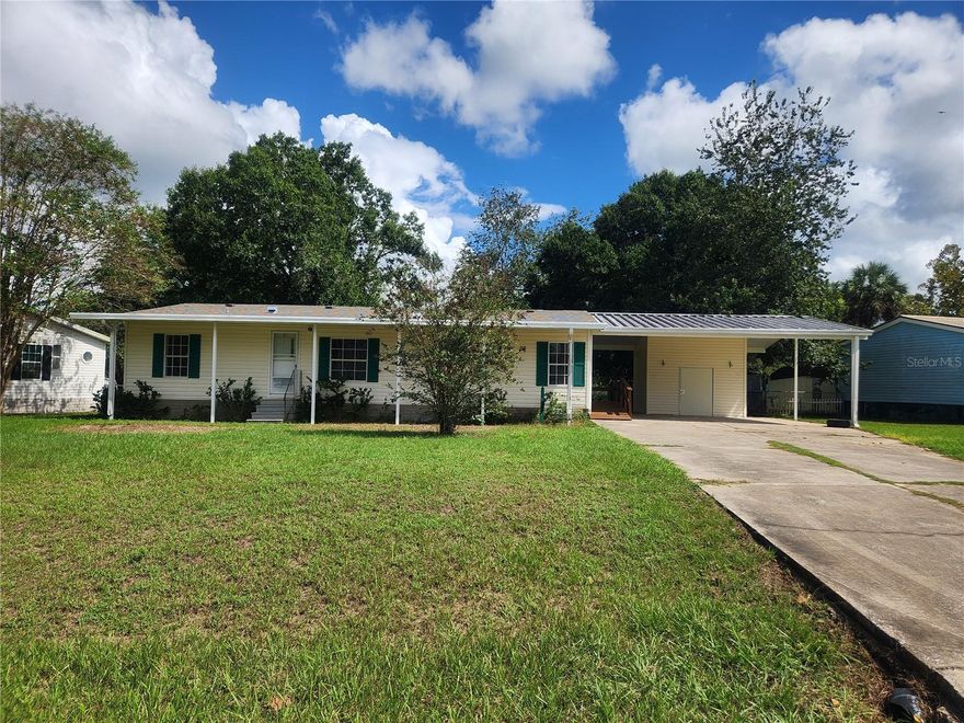 Spacious and in town. This affordable 3 bed 2 bath home has room for everyone and CAN BE FINANCED. Sitting on a dead-end paved road, this SPACIOUS home is newly UPDATED and waiting for its next owners to call it their own. Features a PERMANENT PAVED CARPORT, paved driveway, paved floor storage room, indoor laundry, RAMP accessible to the kitchen door, and a 14x16 DECK overlooking the LARGE FENCED BACK YARD with no back yard neighbors. Plenty of room in the master bed and living room, and a fireplace. Across from Silver Springs State Park, this home feels like it is in the quiet countryside, but it is right on the edge of town with a SHORT drive to Walmart, grocery stores, restaurants, the Cross Florida Greenway, or the Ocala National Forest. UPDATED pipes, NEW roof, NEWER HVAC, NEW paint, NEW flooring, this one is ready for you to call it yours.