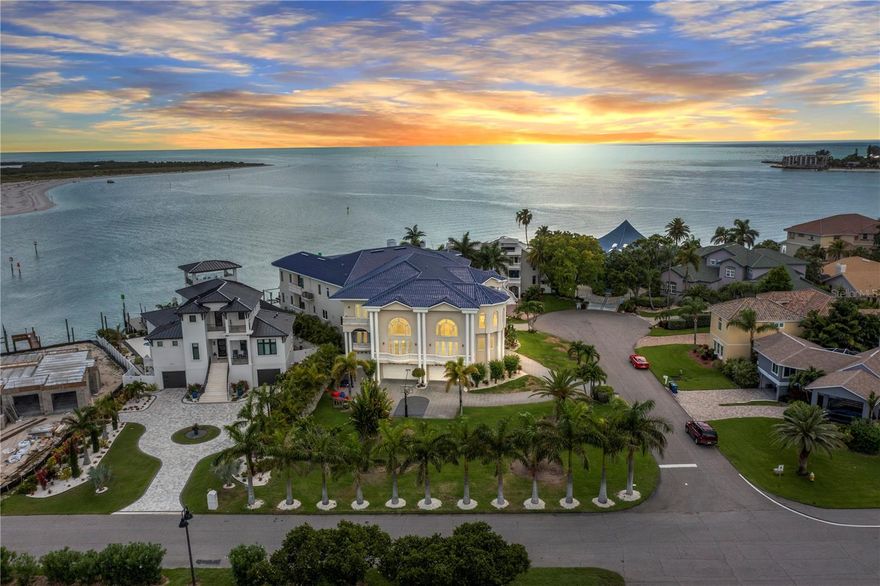 NO FLOODING in this ALL BLOCK/POURED CONCRETE on all THREE levels home.
This stunning estate with sweeping views of the Gulf of Mexico offers pure luxury and comfort! Situated on a double lot, with over 88 feet of water frontage, you will find some of the most open-water, breathtaking sunset views in all of Tampa Bay. Elegantly designed and crafted with poured concrete between levels, hosts over 25,000 square feet under the roof. The home features six grand bedrooms, each with walk-in wardrobes and en-suite bathrooms. The chef's kitchen is adorned with exotic emerald granite countertops and backsplash, equipped with double sinks, professional gas range, and luxury appliances. The entertaining kitchen is attached by a laundry room and butler's pantry and features a matte black marble countertop and island, hexagonal gold-lined marble tile, open brass shelving, and a full-size wine cooler. 

The grand formal living area features an exquisite wood fireplace hearth that extends to the ceiling and sliders out to the second-floor lounge deck. Every inch of the property showcases luxury upgrades and meticulous attention to detail including tray ceilings with wood inlay, intricate crown molding, built-in surround sound, custom electric blinds, whole house vacuum system, and so much more. The main-level primary suite boasts a glamorous dressing room with custom cabinetry, shelving, and glass displays. Both primary en-suites feature double water closets, massive double vanities, soaker tubs, and frameless glass enclosed showers. 

If you are a boater, you will appreciate that there are no fixed bridges, deep water, direct access to the Gulf of Mexico and the proximity to Shell Key.  Bring all of your toys as there is plenty of room in this 8-car garage with workshop and plenty of extra storage. Minutes to the beaches and less than 35min to Tampa International Airport this luxurious masterpiece is ready for its new owner.