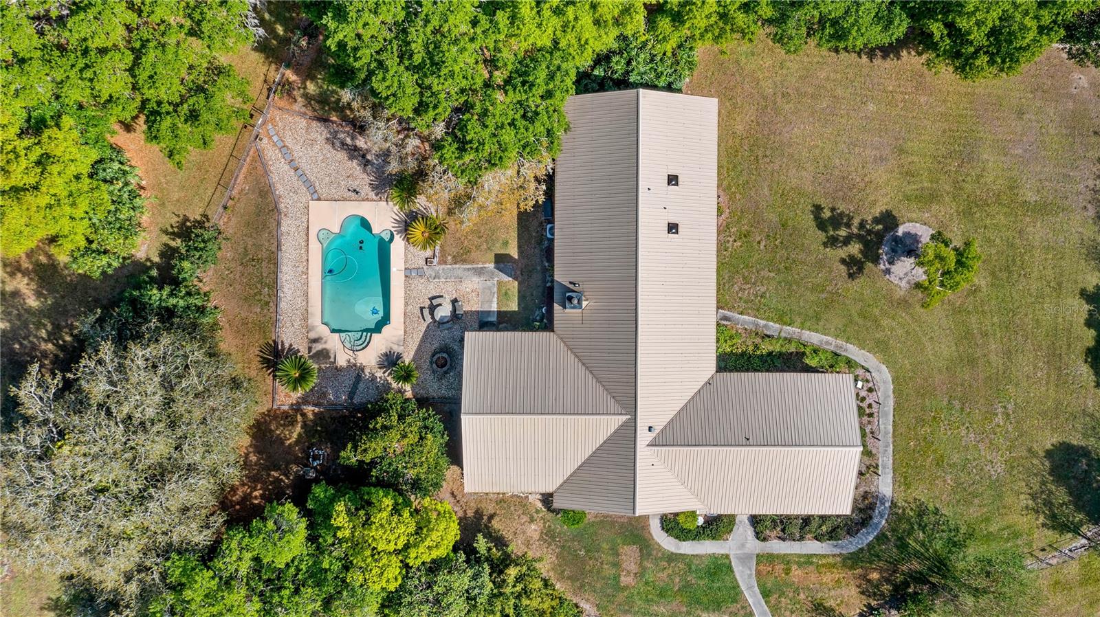 OVER 5 Acres with a 5/3 POOL HOME....AND you can make the HUGE office/flex space in to a 1/1 In-Law Suite or Rental. This home has over 3,800 SqFt total so it’s great for gatherings and for all of those that need LOTS OF SPACE. Take a virtual video tour now by clicking on this link https://vimeo.com/1070130346 Big OPEN living/dining/kitchen space with a wood burning fireplace surrounded in stone. This area opens to back covered carport/porch and beautiful inground pool. Ohhhh YESSS you read that right, 5 bedrooms PLUS a flex room with over 500 SqFt of space that is currently used as office spaces however would be a great rental space that has separate entrances, a full bathroom and walk in closet next to it. Several detached buildings like a 4 bay garage building for all of your cars and toys. A beautiful pool to cool off in on those hot Florida summer days. Plenty of room for all of the animals and to park the RV, Boats and Toys, NO HOA and guess what?!?! This acreage is ALL HIGH AND DRY in the X flood zone so you can use it all for horses, goats and cattle grazing. Located in South Lake County with a short 8 mile drive to downtown Groveland and 13 mile drive to downtown Clermont you're minutes to all things needed and fun. Shopping, farmers market Sundays, dining, entertainment, splash pad, public boat ramps and the amazing Clermont Chain of Lakes. You can be to most of Orlando's offerings, theme parks and Walt Disney World® in 35 minutes. Feeling salty? Take a 90 minute drive east or west to one of Florida's World Famous Beaches for some Vitamin Sea. This place has it all, the space, acreage, pool and more. What are you waiting on? Book your private tour today!