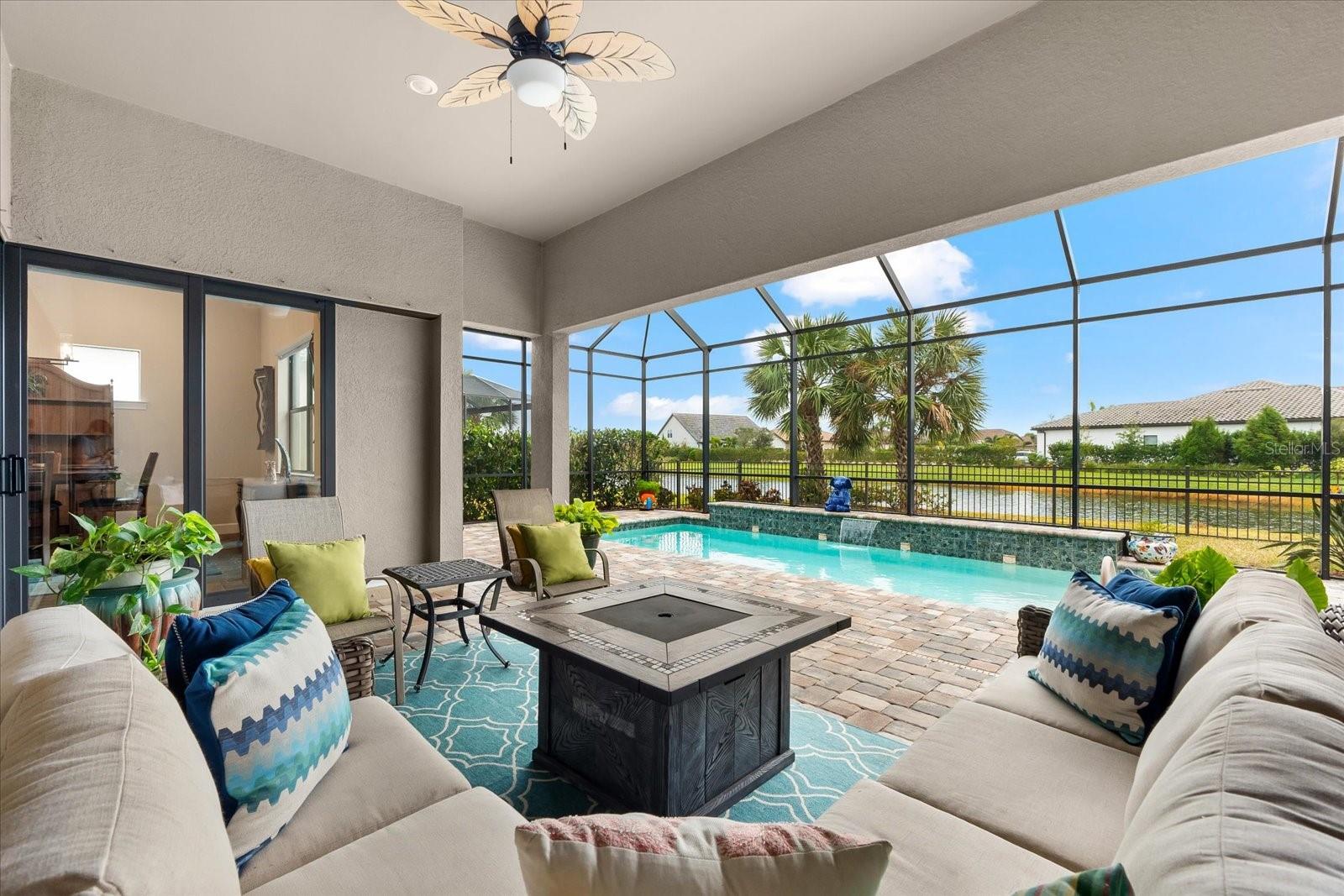 INTRODUCING THE PERFECT PINNACLE! Prepare to be captivated by this exceptional PINNACLE MODEL, featuring an enchanting water view and nestled in the highly sought after 55+ community of Del Webb within Lakewood Ranch. Offering the ultimate in luxurious Florida living, this showpiece blends timeless elegance with modern upgrades blended with traditional style and functionality. With 3 bedrooms, a den, and a thoughtfully designed layout, this home is perfect for both entertaining and everyday comfort. Special touches are showcased throughout, including plantation shutters, tray ceiling in owner’s suite, coffered ceiling in gathering room, and modern fans and lighting fixtures throughout. The heart of the home is the spacious gathering room, which flows seamlessly into the chef’s dream kitchen. This gourmet space boasts a massive island with seating for 4 and chic pendant lighting, 42” cabinetry, elegant quartz countertops, granite sink, stylish backsplash, gas cooktop, and an impressive wood hood. The home is adorned with medium-toned plank tile flooring, complemented by plush carpet in the bedrooms and large square tile in the owner’s bathroom. For an ideal indoor-outdoor experience, open the zero-corner sliding doors to reveal a covered extended lanai. Here, you’ll find a large, heated pool with a mesmerizing waterfall overlooking a serene water view, with a fenced yard perfect for pets. Retreat to the expansive owner’s suite, complete with a cozy sitting area and a spa-like ensuite. This private haven includes dual sinks, a large walk-in shower, and an oversized custom walk-in closet outfitted with drawers, shelves, and abundant hanging space. Two additional guest rooms, one with its own ensuite, offers comfortable accommodations for friends and family. The den provides versatile space, ideal as a home office, gym, craft room, or whatever you envision. And there’s more! This home is brimming with additional premium features, including a whole-home generator, double-paned windows, 4-ft garage extension with an epoxy-coated floor, and attic storage with pull-down ladder access. Opportunities like this don’t come often. Act quickly to make this extraordinary PINNACLE MODEL in Del Webb yours and experience the pinnacle of luxury living. Schedule your private tour today