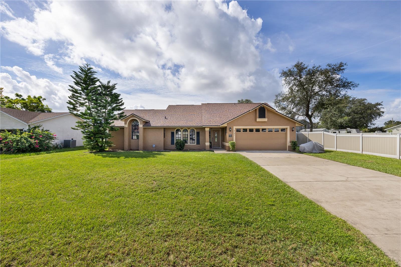 Welcome to this spacious 3 bedroom, 2 bath, 2-car garage home offering a perfect blend of comfort and functionality. Step inside to find vaulted knock-down ceilings, ceiling fans, and tile flooring throughout for easy maintenance and a fresh, airy feel.
The home features a formal living and dining area plus a central kitchen overlooking the family room, complete with stainless steel appliances, breakfast bar, and ample cabinetry—ideal for everyday living and entertaining. Cozy up by the wood-burning fireplace surrounded by built-ins or enjoy the convenience of an indoor laundry room and working intercom system.
The primary suite offers a relaxing retreat with a jetted tub, raised vanity, and dual sinks. Other notable features include an owned security system, exterior flood lights, attic stairs with automatic lighting, and a termite bond for peace of mind.
Step outside to your oversized, fully fenced yard and unwind on the large screened lanai, perfect for enjoying Florida’s weather year-round. Freshly painted in a neutral color palette with a roof only 1.5 years old, this home is truly move-in ready.