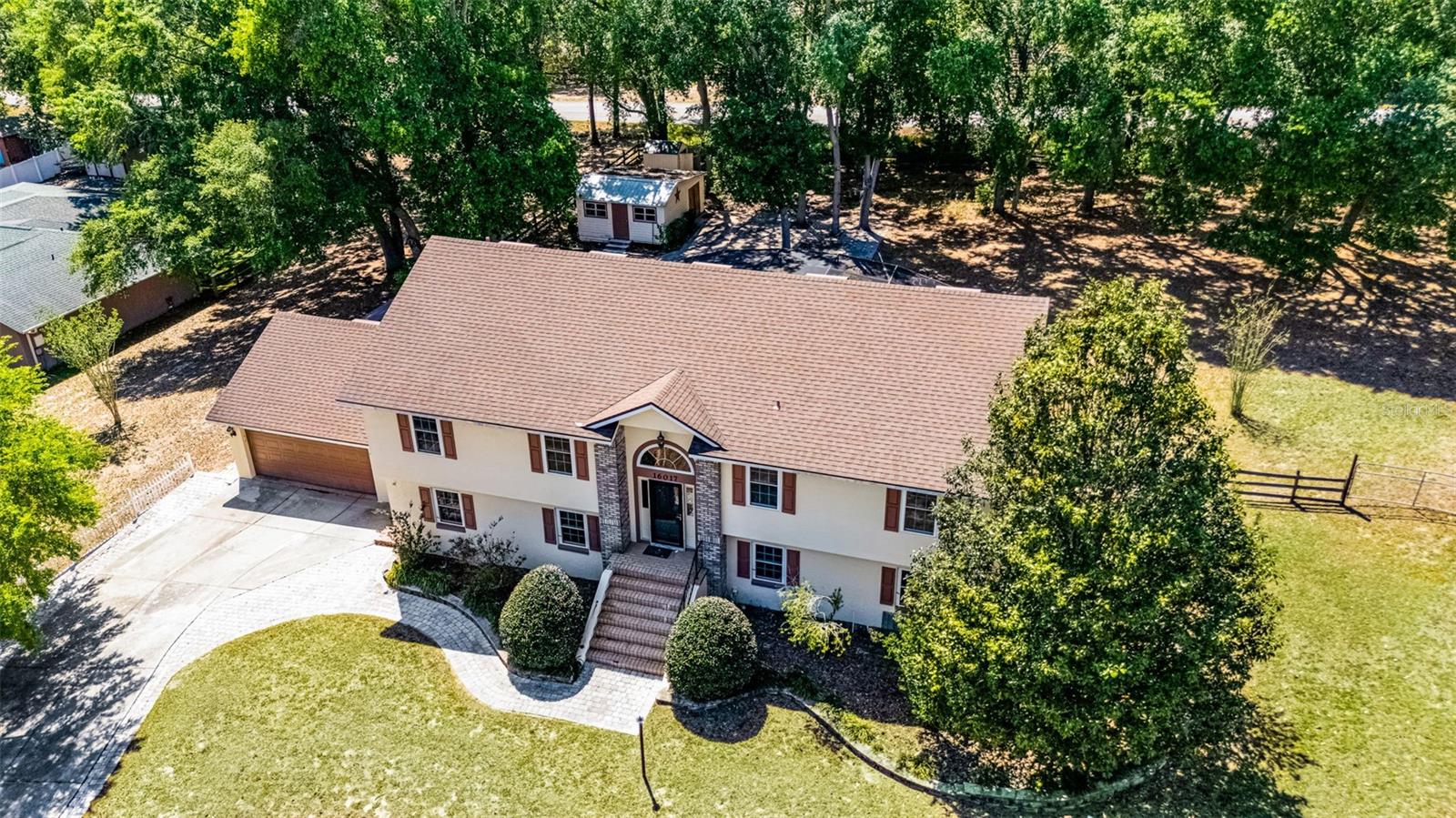 PRICE IMPROVEMENT + $5,000 Seller Concession to Buyer at Closing!! Spacious Custom Pool Home on ½-Acre in Montverde! Beautifully maintained, custom-built split-level pool home on a serene, oversized wooded lot. Located in desirable Montverde with no HOA, this home offers peaceful country living minutes from shopping, dining, and major highways. Interior features include wood floors, vaulted ceilings, crown molding, wainscoting, and custom built-ins. The spacious kitchen boasts granite countertops, abundant cabinetry, and new smart double wall ovens and microwave (2025), opening to a large living room with fireplace. The split-bedroom layout includes a renovated primary bath (2025), two additional bedrooms, and a full bath. The lower level is perfect for entertaining, with a large family room, game room with pool table, two extra bedrooms, and a full pool bath. A loft with built-in desk and daybed is ideal as a study or guest space. Outside, enjoy a refinished pool/spa, screened outdoor kitchen, covered porch, and peaceful backyard with mature trees, ambient lighting, and a fire pit. Additional features: garage-sized workshop, third tandem garage/storage, newer roof, fresh interior/exterior paint, and dual A/C units (2021). Move-in ready!