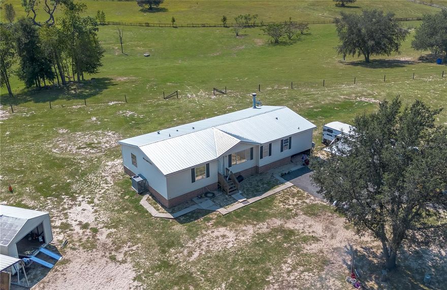 Welcome to a world of opportunity and this sprawling 10-acre hilltop property that offers 360-degree views and a fully fenced yard that is ready for horses. Features gently rolling terrain, perimeter fencing, and two outbuildings ideal for tack, feed, or equipment. Zoned A-1 with no HOA, giving flexibility to add barns, paddocks, or an arena. Just over 11 miles from the World Equestrian Center. The 3 bedroom, 2 bath home offers an open floor plan, fireplace, skylights, screened porch, and inside laundry. A private flag lot setting makes this an excellent equestrian retreat with plenty of room to create your dream farm.