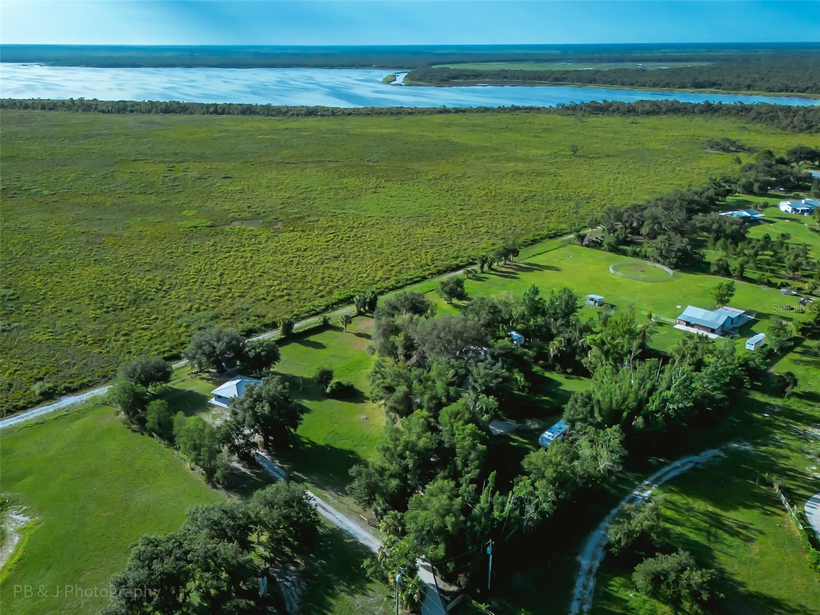 2 HOUSES! RARELY AVAILABLE 5+ Acre Horse Estate is 1 of 5 homes bordering the upper portion of Myakka River State Park (Largest State Park in Florida over 28,875 acres). Every day offers incredible Sun Rises and lake views that shimmer in the early morning sun. This Majestic Property is located at the back of community where everything is HIGH & Dry *NOT in a flood zone* Property is zoned multi-use OUE1 and offers 2 separate well maintained Light & Bright BLOCK homes each with their own well and septic. As you drive through the gate into this unique estate, you are welcomed with mature trees along the 6” thick Concrete driveway leading you up to the main house with a circular drive at the end. Going off to the left after coming through the gate, you will find the driveway to the 2nd home. There is over 100+ yards of concrete throughout the property to help keep it neat and clean. Main home features 3br (ALL WITH WALK IN CLOSETS), 2ba, 2 car garage, laundry/mudroom, outside shower, open floor plan, and wood burning fireplace. Kitchen features stainless appliances, solid surface counters, tile backsplash, and closet pantry. Off the dining/kitchen area, is a screened porch with hot tub perfect for soaking while watching the beautiful Florida sunrise. Enjoy the additional large wood deck with bench seating overlooking the lush flower garden, koi pond, and state park. Follow the concrete walkway that leads you to what the seller refers to as "THE DOLL HOUSE" a 12 x 12 shed/tiny house with metal roof, A/C unit, electric, and a wooden front porch. *Roof is 5yrs old* New Electrical Panel in 2022*. The 2nd house is 2br 1 ba, 744 sq. ft. built in 2008 boasting a concrete pad that surrounds the entire home, Metal Roof, open floor plan, spacious front screened porch and laundry/mud room. The kitchen features wood cabinets and granite counters. The HORSE Barn is 1,278 Sq Ft (36X35.5) and features 3 Horse Stalls:12X10'6'' (currently being used as 2 larger stalls for the 2 horses that live here), Tack Room: 11'4''X13'10'', Feed Room: 8'X13'10'', Horse Wash Station, Center Isle 10', a "Run In Stall" that connects with the 2 pastures 12'X12' and also a round pen. Approximately 3 acres of lush pastures for your horses to enjoy with safe cross fencing to make 3 pastures. Exotic animals are welcomed with proper permitting. This property also offers a secluded private setting. Bring your RV, 30 AMP Electrical hookup on the side of the property just for that purpose and plenty additional room to bring all your other toys (boat, ATV, golf cart, and kayaks). Myakka Valley Ranches is comprised of approximately 300 5+ acre parcels. Saddle up and RIDE onto almost 30 miles of scenic Horse back riding/hiking trails. Twice a month Semitrucks come with an assortment of northern alfalfa, timothy mixed hay, for sale, making it convenient to feed your animals. Every Friday enjoy the Food & Dessert Truck. This Equestrian Community is Conveniently located 7 mi. East of I-75 and about 14 mi. to the white quartz sugar sand of Siesta Key Beach. Myakka River State Park is minutes away and offers miles of Horse-riding trails, hiking, biking, canopy walk, 2 Lakes, Bird Tower, camping, Florida vegetation, amazing wildlife, and evening Concerts. Enjoy this protected preserve as far as the eye can see. Come and explore where you want to live! No Storm Damage.