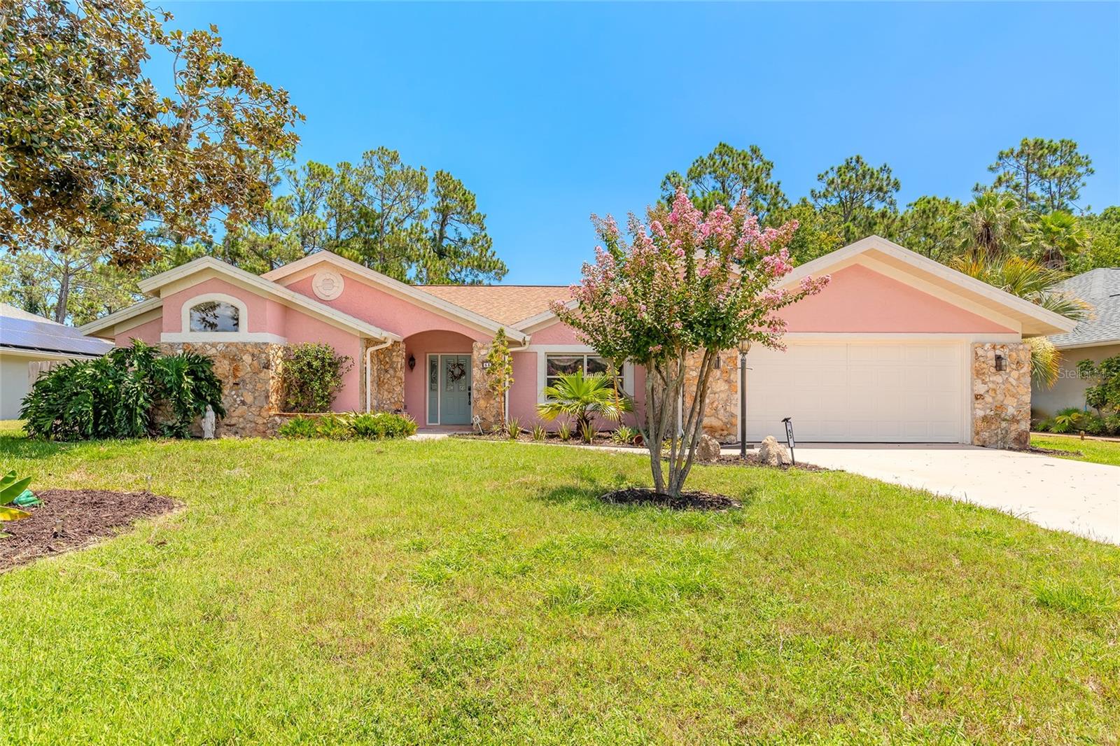 Welcome to your dream home in the heart of the highly sought-after Matanzas Woods neighborhood! This beautifully maintained 4-bedroom, 2-bathroom pool home offers a perfect blend of spacious living, thoughtful design, and true Florida lifestyle. From the moment you arrive, you’ll be captivated by the charming curb appeal, mature landscaping, and welcoming front entry. Step inside to discover a bright, open, and airy floor plan with high ceilings and natural light that fills every corner of the home. The expansive living room is the perfect space to gather, complete with a cozy wood-burning fireplace, creating a warm and inviting atmosphere ideal for family nights or entertaining guests. Just off the living area, the kitchen offers a functional layout with ample cabinetry, plenty of counter space, a breakfast bar for casual dining, and a convenient wet bar, making it a great setup for hosting and socializing. The primary suite is a private retreat tucked away from the guest bedrooms, featuring generous square footage, a large walk-in closet, and a spa-like en-suite bathroom with dual vanities, a soaking tub, and a separate walk-in shower. The three additional bedrooms are located on the opposite side of the home, each offering ample closet space, natural light, and room to personalize—ideal for family, guests, or a home office setup. Step outside through sliding glass doors and enter your own private oasis. The screen-enclosed pool area offers the perfect spot to unwind year-round, whether you’re enjoying your morning coffee under the covered patio or cooling off in the sparkling pool on a sunny Florida afternoon. The fully fenced backyard provides plenty of privacy and room for pets, kids, or even a garden. Additional highlights include a two-car garage, interior laundry room, and updated fixtures throughout. Conveniently located just minutes from top-rated schools, shopping centers, dining, golf courses, and easy access to I-95 for commuting, this home is truly a rare find in one of Palm Coast’s most desirable communities. Don’t miss the opportunity to make this Matanzas Woods gem your own—schedule your private tour today!