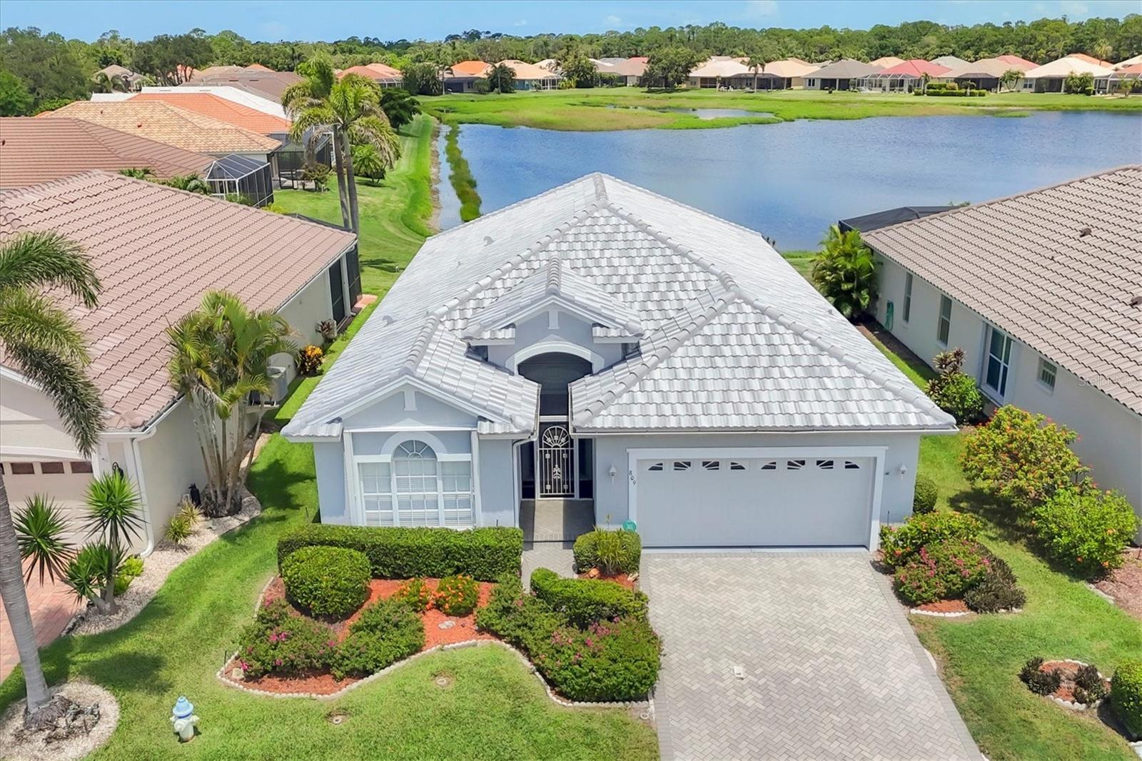 MUST SEE! GORGEOUS LAKE VIEWS WITH SUNSET EXPOSURE! DON'T MISS OUT! MOST POPULAR PLAN IN PELICAN POINTE. This immaculate, 2BD/2BA/Den well maintained home is full of upgrades. First impression curb appeal is off the charts, with a pavered driveway, NEW ROOF, Freshly painted home surrounded by tropical landscaping. HURRICANE SHUTTERS FORM A protecction from storns. Walk into the main foyer and high ceilings, tray inserts, custom arches and niches make this home stand out before you even get to the SPECTACULAR lake view. Open floor plan with kitchen,living room, breakfast nook, and dining room all overlooking each other. Great for entertaining or just casually fixing dinner while watching TV. Beautiful kitchen with granite counters, stainless steel appliances, extra recessed lighting for the cook, Tile back splash and kick guard around the island. Breakfast nook gives you that wonderful view while sitting down for a casual meal. Separate dining room for more formal occasions or holidays with arched pass way through living room, have the whole family over!!! Main floor has LUXURY VINYL flooring with tile flooring in the rest of home. NO CARPET. Through the living area step outside to your extended pavered lanai with SPECTACULAR SUNSETS and a peaceful relaxing view of lake. Separate DEN/OFFICE SPACE WITH FRENCH DOORS TO CLOSE OFF THE MESS , if needed. Large master bedroom with en suite bath offering dual sinks, garden tub, and walk in shower. Guest bedroom at other end of home for privacy with easy access to bath. Not here in Florida to see? Check out the 3D Walk through at: https://my.matterport.com/show/?m=uSUKLjHRnt6 Pelican Pointe is Venice's Premier community offering resort style amenities including Clubhouse with bar/grill, card room/library, and banquet facilities. Heated pool with lap lanes for swimming, fitness center, tennis courts and pickle ball, tons of sidewalks for enjoying the weather throughout the community, and 27 holes of golf with Pro Shop. Tons of social opportunities for non golfers, including trivia night, special occasion activities, and huge Women's association. Golf is NOT mandatory. All of this Centrally located minutes to Venice Beach, Venice Downtown, shopping, theatres, restaurants, highways, airports, and so much more. Venice is the quaint gem you have been looking for on the West Coast.