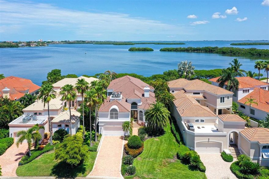 BAYFRONT HOME THAT HAS IT ALL!!!  Located behind the gates of the Longboat Key Club on the Bay Isles Waterway with a protected deep water dock and bay views offering privacy and serenity. .  Built with the highest quality of materials throughout plus a new roof Apr 2022 and several updates made throughout the years, the home is ready for you to move right in.  Delight in the open 2 story floor plan with high ceilings and windows galore, 4 bedroom suites including a guest suite with kitchenette, library/den, formal dining room, living room, exercise or hobby room, bonus room, and an expansive kitchen/ family/ breakfast  room. The home is equipped with natural gas used to efficently heat the pool, water, & appliances.  There is an internal vacuum system, water filtration system, in-wall pest control system, Pentair remote pool system, instant hot water dispenser, zoned AC with 5 thermostats, and ring security system.  For the boating enthusiast, the dock of composition material has water & electric, will accommodate at least a 40’ boat, and you find yourself only minutes to the open bay and Intercoastal waterway.  A beautiful pool/spa and patio sets the perfect  scene for watching the evening sunsets while all awhile sipping on your favorite beverage. No need to worry about storms, there are electronic shutters which also double as security shutters.  Location is ideal, close to the Publix Shopping Plaza, St Armands Circle, and a short drive across the bay to all the amenities of downtown Sarasota.  To  top this all off, included is a membership to the coveted Bay isles Beach Club on the azure waters and white sandy beach of The Gulf of Mexico. Memberships are also available to THe Longboat Key Country Club & Resort offering 45 holes of golf, 6 resturants, fitness center, spa, tennis, & pickelball.