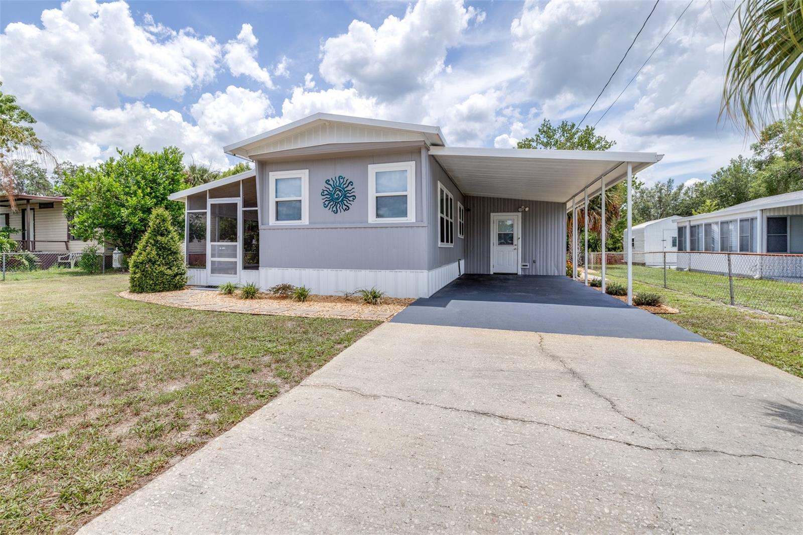 Welcome to your move-in-ready WATERFRONT getaway, nestled on a peaceful canal with direct access to the beautiful Henderson Chain of Lakes. This charming 2-bedroom, 1-bath mobile home has been thoughtfully updated and is bursting with character, comfort, and functionality, without the burden of HOA, CDD, or park fees.
Step inside to find an open-concept layout featuring a spacious living and dining area, an eat-in kitchen with stone-look backsplash, newer stainless steel appliances, and easy-care waterproof laminate flooring throughout. Enjoy even more living space with a large family room and separate den/flex room, both filled with natural light and serene water views, not included in the heated square footage. These bonus spaces provide quiet spots to relax, work, or entertain while enjoying the beauty of the surrounding butterfly garden. This gem is being offered partially furnished, including a TV in the family room and beds in both bedrooms.
Outside, unwind on the wooden DECK (with retractable awning) or gather around the firepit under the stars. The DOCK has been freshly redone and is ready for your boat plus, the community BOAT RAMP is just $15/year. The lot is fenced on both sides, and a covered carport and storage shed add practical convenience. The home is located in flood zone X for the main structure, with only the canal area falling into AE, providing additional peace of mind.
Major updates include a HVAC system (2023), supplementary split A/C unit (2024), water heater (2025), well pressure tank (2024), water softener with iron filter, and washer/dryer (2024). Several windows have been replaced with double-panel, energy-star certified models and all windows come with blinds. An A/C unit has also been installed in the indoor laundry room. The renovated bathroom features a double granite vanity, and stylish lighting adds a modern touch throughout.
Schedule your private showing today! Due to the manufacture date of the home, this will be a CASH ONLY sale.