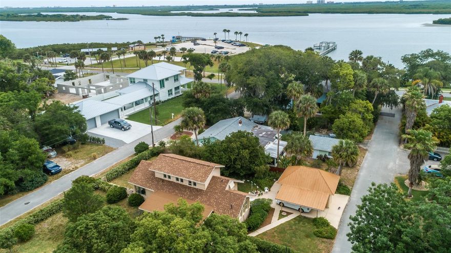 PRICE REDUCED!! Seller is willing to contribute up to 5k towards buyers closing costs! Looking for an adorable, immaculate Riverside home on a DOUBLE LOT with a MOTHER IN LAW SUITE? This is it!! This home features a street to street oasis surrounded by natural flowering Mother Nature for complete and total privacy. Located a few homes off of the River and Riverside drive; this adorable 3 bedroom, 2 bath 1920's home has been well cared for and features updates to the electrical, plumbing, AC unit(s) and hot water heater as well as a BRAND NEW roof. This cozy home features 2 bedrooms and 1 bathroom downstairs with your living, kitchen and dining areas as well as two large outdoor porches - Perfect for indoor and outdoor entertaining and room to grow. In the upstairs you will find a complete mother in law suite with 1 bedroom, 1 bath and full kitchen and living area. This home can be moved right into or you can put your own personal touch on it. Great for investors as well for multiple streams of rental income! There is also an outdoor patio area and detached large garage with carport. This amazing home is located right next to Menard - May  park & public Kayak launch on the River, Public Boat ramp and is golf cart distance to everything in Downtown New Smyrna and the BEACH! Schedule a showing today - This home will not last! All information deemed accurate but cannot be guaranteed. Buyers encouraged to verify all information important to them. ;Water: City