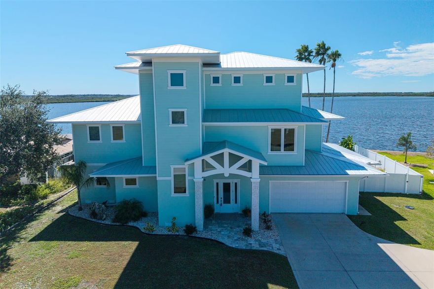 Step into coastal elegance with this extraordinary 3-story waterfront pool home offering over 4,000 sq. ft. of thoughtfully designed living space, built in 2022. The ground level includes a spacious garage, under-stair storage, an oversized air-conditioned flex/game room, & a large storage area for fishing gear, paddleboards, kayaks, & all your waterfront toys. Stained concrete flooring, mini-split A/C, & storm-ready half walls provide both form & function. On the second floor, the main living space unfolds with breathtaking views of Dixie Bay from every angle. The open-concept great room flows into a chef’s kitchen with quartz countertops, a 6-burner gas stove, pot filler, double ovens, ice machine, walk-in pantry. A stylish geometric shelving unit that enhances a cozy reading nook. An expansive balcony showcases a summer kitchen with marine grade stainless grill and side burner. A spiral staircase leads down to the sparkling pool & travertine-decked patio below. Relax in the LP-heated pool & spa. Also on the second floor are two beautifully appointed guest bedrooms, a sleek modern guest bathroom, & an artfully designed half bath. The third floor features an oversized laundry room with a steam shower & views of the bay. The primary owner’s retreat is simply spectacular—wake up to panoramic water views, unwind in the soaking tub surrounded by windows, or step out onto your private balcony with a secluded outdoor shower. The en suite also features dual vanities, a walk-in shower, & an oversized custom closet system. Additional highlights include: 9,000 lb covered boat lift, dock with fish cleaning station & dual freshwater hookups, new seawall & cap,  elevator, tankless water heaters, Hunter Douglas Motorized remote-control window shades, vinyl privacy fencing, 500-gallon propane tank, WearDeck outdoor surfaces. Just 5 minutes to the Gulf, 15 minutes to the scallop grounds, this home offers a rare blend of high-end craftsmanship, and modern luxury. ***Measurements to be verified by buyer. Qualified buyers only