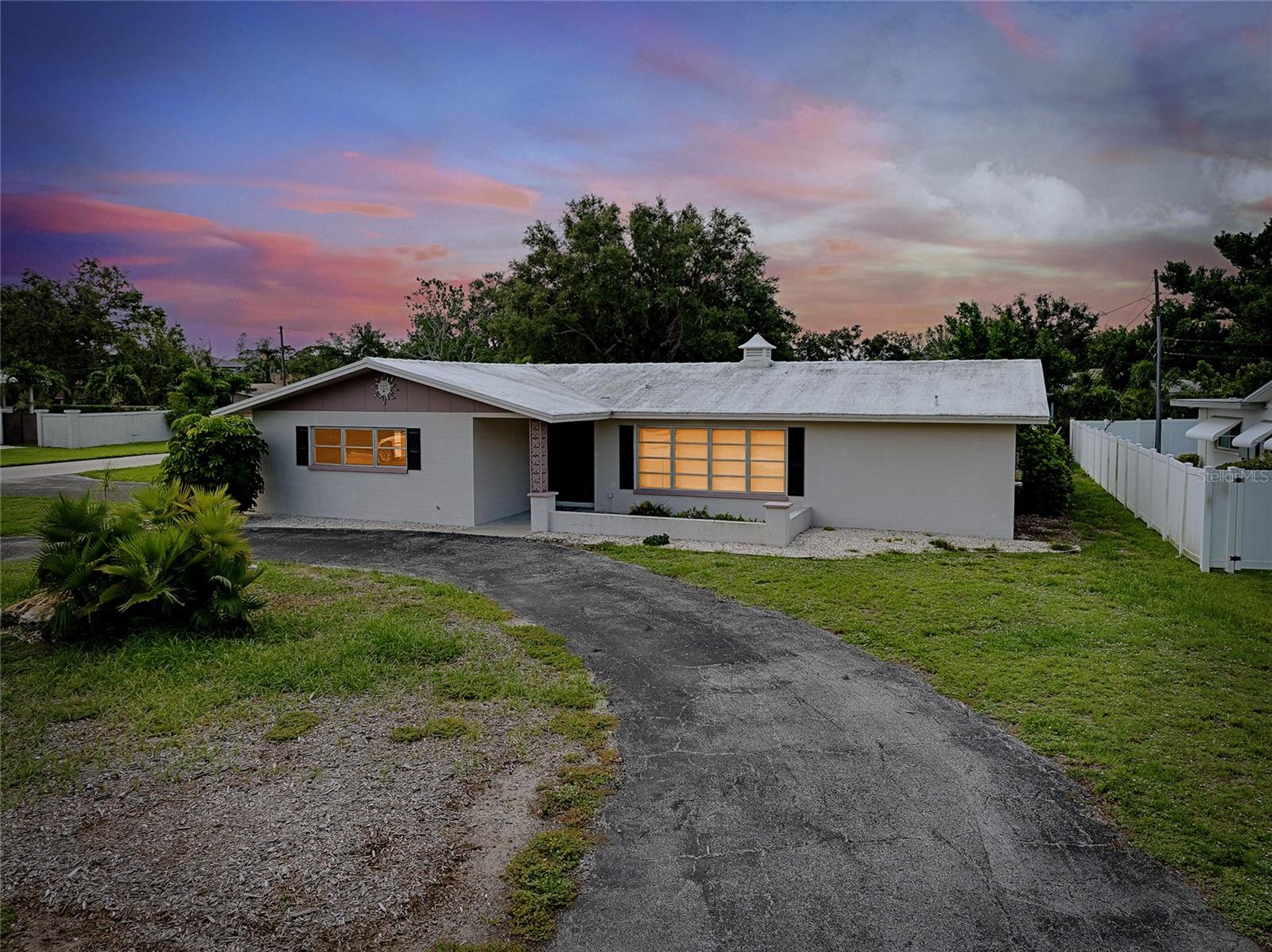 CHARMING COASTAL HOME ON RARE OVERSIZE VENICE ISLAND CORNER LOT: Nestled away on the desirable north side of Venice Island, this charming 2-bedroom, 2-bath block home sits on a rare oversized corner lot with over 12,500 square feet of land—offering both space and opportunity in one of the island’s most sought-after neighborhoods. Designed for functionality and future potential, the property affords a spacious side-entry two-car garage featuring its own dedicated driveway, complemented by a separate circular driveway out front, creating ample parking for residents and guests alike. Inside, the home boasts a large open kitchen complete with a movable central island, custom cabinet pullouts, and abundant counter space—ideal for cooking, entertaining, or casual gatherings. Pocket sliding doors open to a generous size screened lanai with stamped concrete flooring, seamlessly blending indoor and outdoor living. Whether you are enjoying a peaceful morning coffee or hosting friends for a sunset gathering, the lanai offers the perfect space to relax and envision future enhancements such as a pool, spa, or outdoor kitchen. Showcasing a split-bedroom layout, the floorplan ensures privacy, with both bathrooms featuring tiled showers and ample space. The home is equipped with a 2019 HVAC system and offers just under 1,300 square feet under air, providing a cozy and efficient floorplan that is move-in ready or ready for your personal updates. Located just a short stroll from West Venice Avenue, this home places you minutes from boutique shopping, fine dining, seasonal festivals, and Venice’s vibrant farmers market. The Gulf beaches, known for their soft sand and legendary shark teeth, are just down the road, offering four miles of breathtaking coastline to explore. Whether you are seeking a full-time residence, winter escape, or a blank canvas for your dream coastal retreat, this property delivers the lot size, location, and lifestyle that make island living so exceptional.