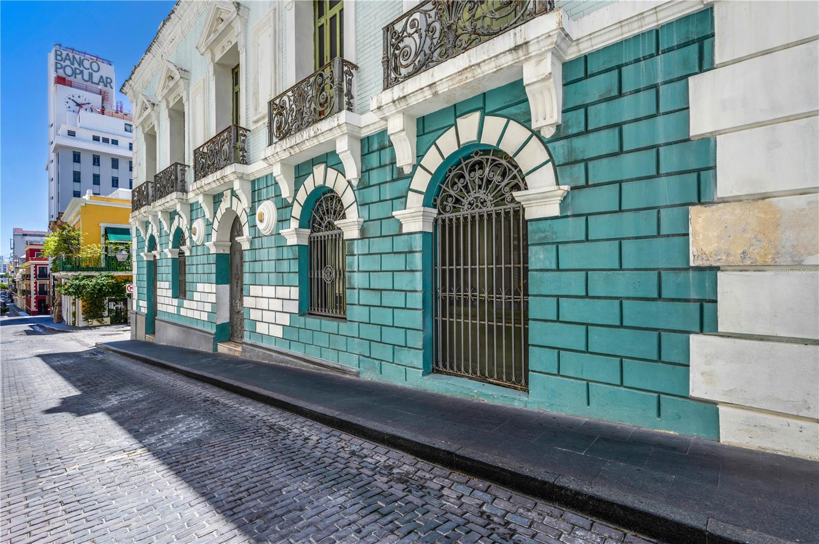 A landmark of architectural and historical significance, 152 Calle de Tetuan once housed the prestigious Spanish Bank, inaugurated in 1894 as a cornerstone of Puerto Rico’s financial past. Set along Tetuan Street, once the island’s bustling financial district, this property carries with it the legacy of culture and Old San Juan’s golden era. Today, the building stands as a rare opportunity to reimagine a piece of history. Spanning three expansive floors, the interiors feature an open floor plan with soaring 19-foot ceilings, inviting abundant natural light and endless design possibilities. The property also boasts a usable rooftop, which can be enclosed into a signature amenity space or transformed into an outdoor terrace with panoramic views of the bay and San Juan’s port to the south, an ideal setting for entertaining or enjoying the city’s maritime landscape. Whether envisioned as a grand private residence or a distinguished legacy estate, 152 Calle de Tetuan offers the perfect canvas. Its location at the heart of Old San Juan, coupled with its rich heritage and architectural character, makes it one of the most unique and versatile properties available in Puerto Rico’s historic capital.