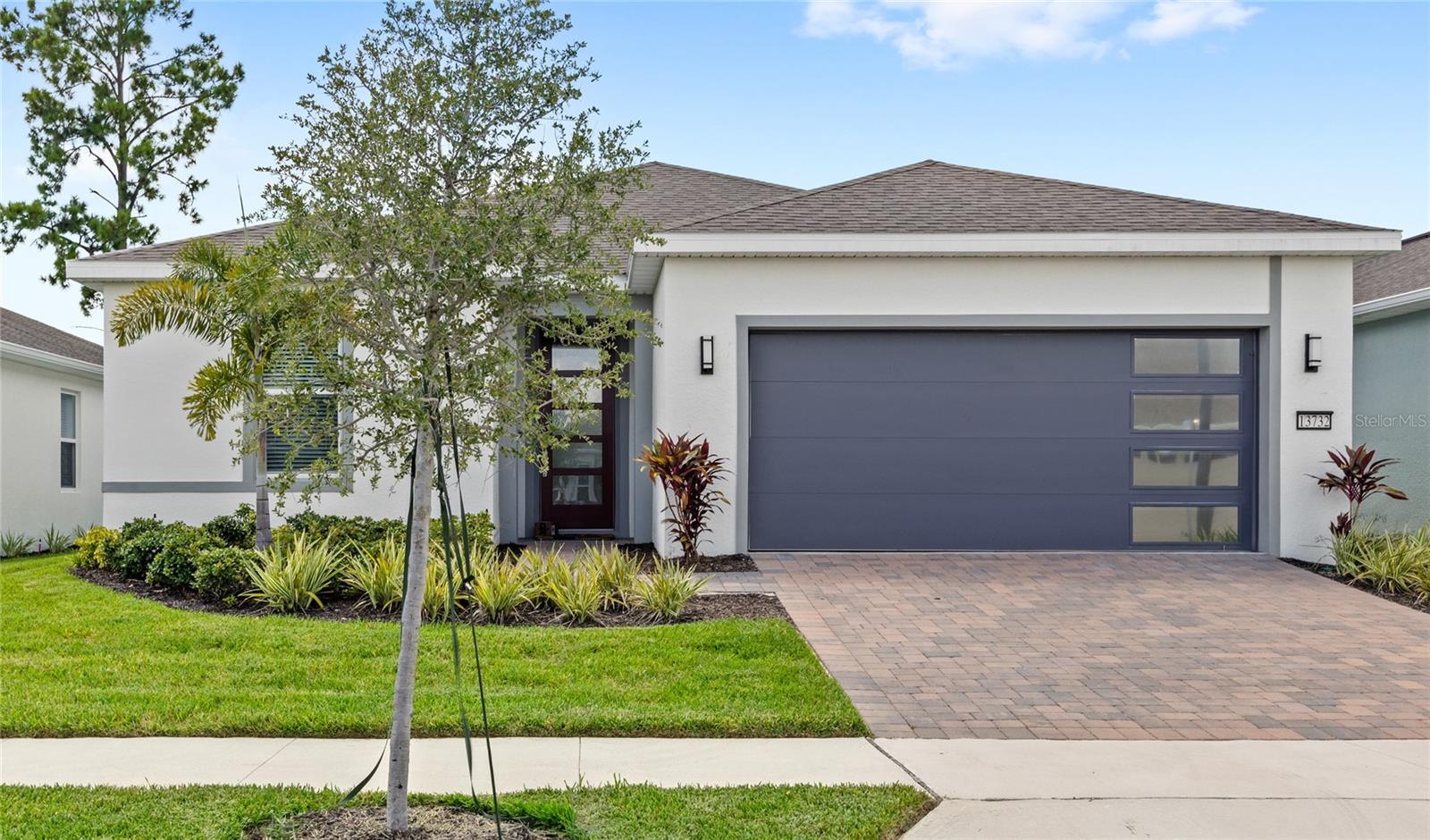 Not your average Del Webb home—this nearly new, designer-upgraded retreat offers rare touches and nightly Disney fireworks views. Why wait to build? This home is just under a year old and move-in ready, located in the vibrant 55+ community of Del Webb Oasis, where resort-style amenities include a clubhouse, zero-entry pool with cabanas, tennis, pickleball, and more. The open-concept floor plan features 2 bedrooms, 2 baths, a versatile flex room, and an upgraded kitchen with quartz countertops, soft-close cabinets, stainless appliances, and a designer backsplash. Enjoy luxury vinyl plank flooring, tray ceilings, an extended covered lanai prepped for an outdoor kitchen, custom closet systems, and over $30K in premium finishes. HOA includes lawn care and high-speed internet. Thoughtfully designed and perfectly located—this home offers comfort, style, and a touch of magic.