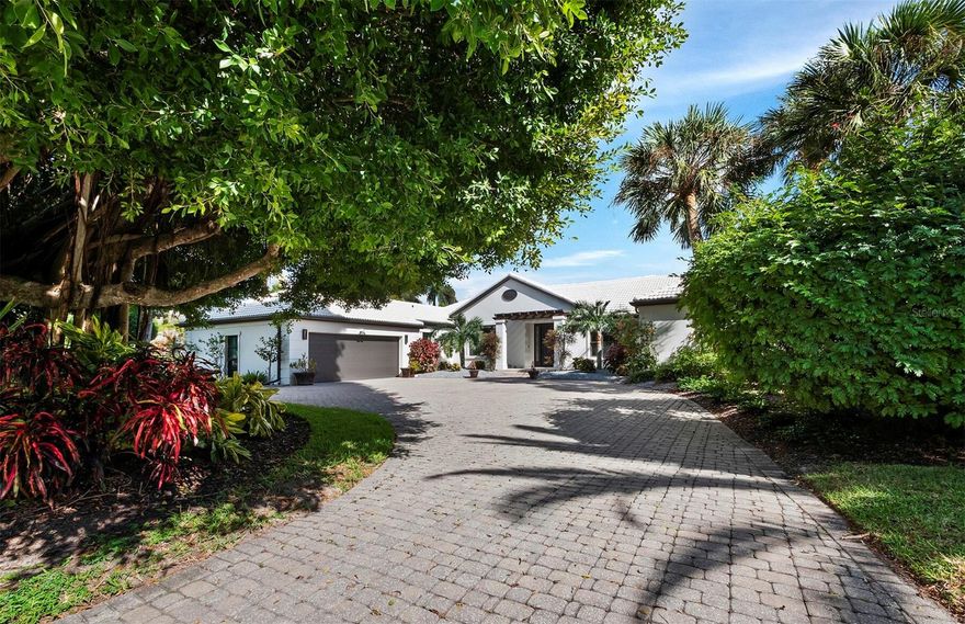 Contemporary elegance meets serene waterfront living in this exquisite 3BR plus den/3BA residence on 100’ of prime Bird Key water frontage, just moments from downtown Sarasota, vibrant St. Armands Circle and pristine white sand beaches – the best our area has to offer. Lush, mature landscaping envelops the expansive circular driveway, setting the tone for what lies beyond. As you step inside, be captivated by the beautifully updated interior, featuring engineered hardwood floors and soaring tray ceilings adorned with recessed lighting. The foyer gracefully opens to a dining room and a large living space with a striking accent wall and sliders leading to the open pool area. The kitchen, a masterpiece of modern design, seamlessly adjoins the living room and boasts a center island with a multi-level breakfast bar, low-profile contemporary cabinetry, stainless steel appliances, a wine refrigerator and a stately tile backsplash. A bonus Florida room, surrounded by glass, opens to the tropical oasis outside. With a wet bar and a soaring tongue and groove ceiling, this space offers both comfort and style. The large primary suite beckons with access to the open pool area and a vast walk-in closet featuring a center island. The voluminous primary bath is a retreat in itself, with dual vanities, stylish flooring and a spacious walk-in glass shower with rock-style tile accents. A separate water closet adds a touch of luxury. Step outside to the open pool area, a true tropical haven ideal for entertaining or simply relaxing, with large paver tiles, an oversized covered space featuring a gorgeous tongue and groove ceiling, and a convenient summer kitchen. Begin your nautical pursuits from your private dock, where Sarasota Bay and the Gulf of Mexico are a short boat ride away.