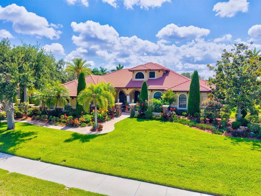 If you've been dreaming of a home that actually lives as good as it looks, this is it. This magnetic home is tucked inside the gated community of Serenoa, where lots are sized from half an acre to over an acre, streets are lined with trees, and there's a golf course right in the neighborhood (membership is optional).  This 4-bedroom, 4-bath home with a private office, bonus room, loft, and fitness room has everything you could want under one roof and in a wonderful sought after gated community.

Pull up and you'll immediately notice the brilliant curb appeal. A paved courtyard with a fountain and lush tropical landscaping gives it that "wow" moment before you even step inside. The front door is a custom steel door that was added in 2020, a lovely impression that leads to the welcoming foyer with designer tile, elegant archways, a chandelier, and a spiral staircase up to the loft.

The layout is generous and smartly designed. Surround sound is throughout, inside and outside on the lanai. There's a private office with custom built-ins, a formal sitting room, formal dining room, gym, den and loft, offering plenty of room to work from home, host guests, or to simply spread out. Rich tile flooring runs through the main living areas, and the split-bedroom floor plan keeps things private where it counts.

The kitchen is the real heart of the home, which was remodeled in 2020 with new wood cabinets, and quartz countertops. A sprawling island with bar seating and pendant lights, an electric range and hood, stainless appliances, a butler's pantry & a breakfast nook with pool views... it's the kind of kitchen that makes cooking (and entertaining) genuinely enjoyable. The family room right alongside it has a coffered ceiling, fireplace, custom built-ins, and pocketing sliding glass doors that open right up to the gorgeous lanai.

The primary suite is where you'll want to start and end every day. It has direct access to the lanai and pool, a coffered ceiling, a cozy window seat, and a connected gym. The bathroom is well laid out: dual vanities, soaking tub, walk-in shower, and a large walk-in closet.

The guest rooms are roomy and well-placed, and the den, with a wet bar and its own lanai access, is perfect for a secondary flex space. Head upstairs and the loft that offers a bathroom with walk-in shower and balcony overlooking the pool is ready for whatever you need: a guest suite, game room, or quiet retreat.

The outdoor space, front and back is where this home truly shines. The screened lanai wraps around a resort-style walk-in pool and spa with a waterfall, covered lounge areas, three gas fire pits, and an outdoor kitchen with a grill, range hood, sink, fridge, and storage, all with peaceful lake views. Multiple pocketing glass doors make the inside-outside flow completely seamless. New pavers were installed in driveway, walkway and front landing...this is when the unique rounded step entry was added.

The construction of this home is absolutely quality...the foundation was raised by 3 extra blocks, pool cage has 12" side beams & upper 12" beams, yet more additions to the quality and elegance of this home.  The tile roof was covered with Perma-Seal and 2 coats of Uni-flex Paint...a complete list of home improvements is available upon request. This home is solidly built & very well-maintained.

This is a home you have to visit to truly appreciate. Come see it for yourself.