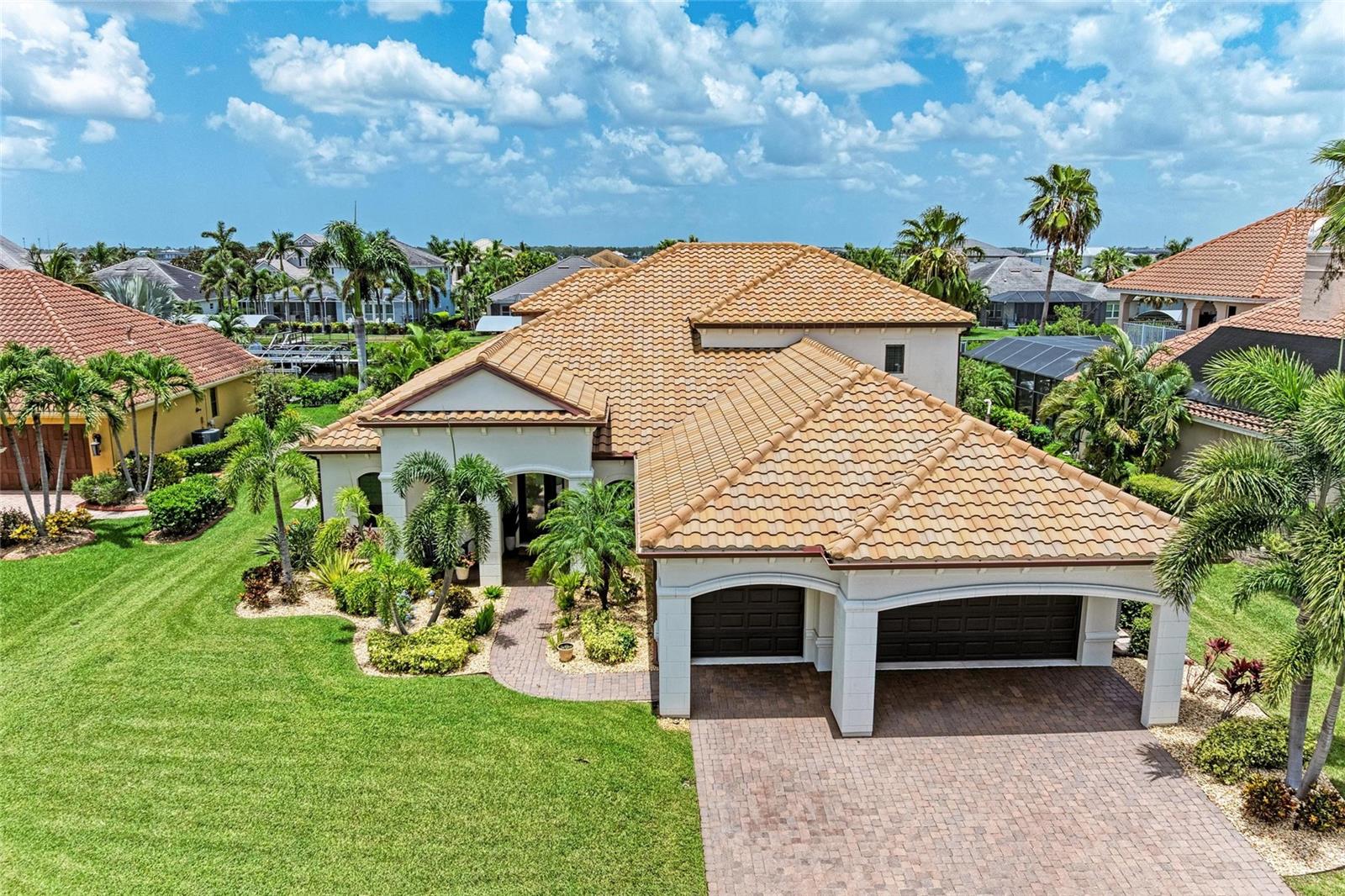 Welcome to this coastal contemporary masterpiece in the gated waterfront community of Harbour Walk at The Inlets. This meticulously maintained and extensively upgraded home offers the ultimate in Florida luxury living. The deep saltwater canal has direct (no-lock) access to the Manatee River, Tampa Bay, and the Gulf. Spanning nearly 3,900 sq ft, this custom-designed residence boasts extensive remodeling, including a stunning primary ensuite bathroom and a chef-inspired kitchen with updated appliances, built-in refrigerator, double ovens, an oversized island, and a generous walk-in pantry ideal for entertaining and everyday living. The open-concept layout features a spacious great room and dining area with breathtaking views of the water. The first floor includes the serene primary suite, a den, and a versatile bonus room, offering flexible living spaces. Upstairs, you’ll find three additional bedrooms, including one ensuite, another full bath, and a large bonus room perfect for guests, media, or recreation. Step out onto the private balcony for sweeping views of the canal and the tranquil Florida landscape. Enjoy year-round outdoor living on the expansive covered lanai, featuring a summer kitchen, an oversized heated saltwater pool with a six-person hot tub, and a no-see-um screened enclosure. Boaters will appreciate the covered boat lift, complete with a composite dock and shore power leading to your next adventure. Watch manatees and fish right from your dock. This home offers the utmost in waterfront living. Additional upgrades and features are available on the feature sheet.
