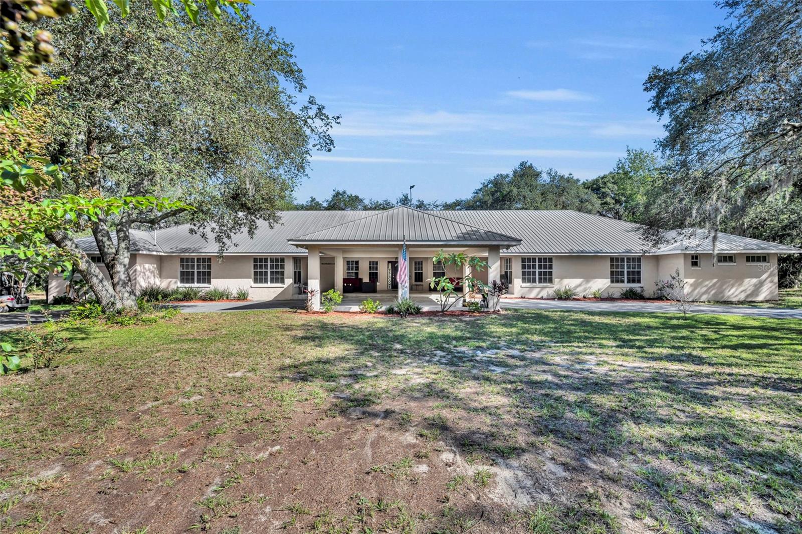 Welcome to 15049 Vinola Drive, Montverde, FL – a rare multi-generational retreat on 4.59 acres!
This property offers an incredible opportunity for both privacy and versatility. The main residence features 3 spacious bedrooms plus a dedicated office, ideal for working from home or flex space.
Attached by thoughtful design is a full in-law/next generation suite, complete with its own 3 bedrooms, 2 baths, family room, dining room, living room and a full kitchen. Perfect for extended family, guests, or even rental possibilities, this separate living space provides comfort and independence while keeping everyone close.
Outdoors, the 4.59 acres provide plenty of room to roam and enjoy nature. A private pond adds to the serene setting, while a workshop and storage shed provide space for hobbies, projects, or extra storage. The wide-open land invites gardening, horses and cows, or outdoor entertaining with a peaceful country backdrop.
This property blends the best of private acreage living with the convenience of being just minutes from Montverde Academy , shopping, dining, schools, and access to major highways for an easy commute.
Whether you’re looking for a true multi-generational home, space for your passions, land for your horse or simply the tranquility of your own acreage with a pond, this unique property delivers it all.