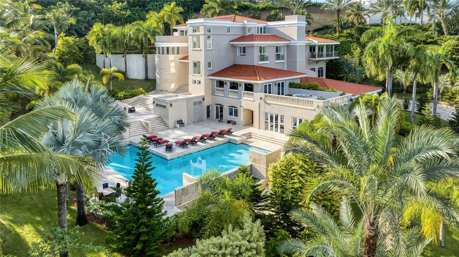 Embrace the best Puerto Rico has to offer with this sprawling estate at the Wyndham Rio Mar Resort. Affording over 11,800 interior Sq. Ft., designed and built to measure, the home showcases one of a kind custom features throughout. Double-height living room with handcrafted coffered wood ceilings and handrails, as well as a commissioned mural for the entertaining space which serves as one of the property's many detailed features. It includes 9 bedrooms and 9.5 bathrooms, in addition to a fitness center, office and fully-equipped kitchen with wine cellar. The gaming room encompasses almost the entirety of the fourth floor, serving as a flex space that can seamlessly be converted into an artist's studio, music room or library. The pool is surrounded by nature, enveloped by vibrant tropical vegetation and lush landscaping that create a magical garden atmosphere. A truly serene retreat and private oasis with unmatched scenery, providing the perfect environment to relax, meditate or host friends and family. The terraces and balconies feature spectacular views of the scenic landscape and the ocean. Rare to market, few properties could compare to this home and the unparalleled resort lifestyle it offers within the enclave of The Wyndham Rio Mar Resort. Located on the East coast of the island, the residence enjoys an enviable location on just under an acre of land. The resort's amenities include restaurants, pools, casino and spa, in addition to fourteen tennis courts and two 18-hole championship golf courses, all within a short drive away from El Yunque National Rainforest. If boating is your passion, it is also within close proximity to the largest marina in the Caribbean. Monthly HOA: $400.
