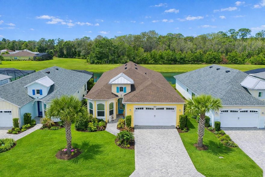 Picture yourself in a low-maintenance, high-leisure lifestyle from the unparalleled Latitude Margaritaville in Daytona Beach! Here is your opportunity to own one of the best Breeze locations in this highly-sought community. Move-in-ready and like-new, this private home is illuminated with Florida sun creating a warm and welcoming atmosphere. As you approach the home you will immediately notice the vibrant paint colors, the beautiful pavered drive, the oversized 2-car garage, and an ornate entry above the front door. Upon entering the foyer one can see through the house to the five panels of sliding glass and onto an extended screened-in lanai. The 14-foot entryway height and the tray ceiling in the Great Room add volume and spaciousness to the ambience. Beyond the lanai's picture-window-sized no-see-um screening there is nothing except water and native vegetation. Various shore birds frequent the far bank. There are also visits from Sand Hill Cranes, egrets, herons, turkeys, deer, and occasionally, a fox. This view, under a western setting sun, gives the illusion of an isolated area even in the midst of Margaritaville. Features inside include recessed lighting, custom fixtures and stunning wood-like tile flooring. The open kitchen will delight the chef of the family with an abundance of wood cabinetry, gorgeous granite countertops with breakfast bar, and a quality stainless steel appliance package. This versatile floor plan provides two full ensuite bedrooms and a bonus den. Latitude Daytona is among the best 55+ in communities in Florida, with residents enjoying a resort lifestyle that includes a private restaurant / bar, a beach club with private transportation, multiple swimming pools, tennis, pickleball and much more. You can even drive a golf cart to the local Publix Supermarket! Don't miss out on this life changing offering!