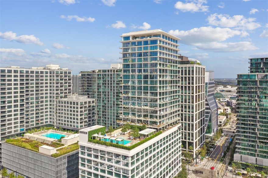 Under contract-accepting backup offers. Discover an unrivaled living experience at The Tampa EDITION Residence 1702, a sophisticated corner unit masterfully designed and framed by sweeping vistas of Tampa Bay, the sprawling downtown skyline, and the visionary Water Street development. This residence epitomizes refined urban luxury.

The exquisite open floor plan flows seamlessly between living, dining, and entertaining spaces, designed to offer an unparalleled experience of comfort and elegance. The private primary suite serves as a luxurious retreat, complete with a spa-inspired bath clad in Polaris White marble, a freestanding Kaldewei soaking tub, a custom double vanity, and ambient lighting that enhances its serene atmosphere. This sanctuary also includes two closets and direct access to a wrap-around terrace with breathtaking views. Two additional bedrooms, each with its own well-appointed ensuite bath, provide sophisticated accommodations for family or guests, while a private den offers the ideal space for relaxation or remote work.

Every element of this home reflects meticulous craftsmanship and elegant design. Expansive floor-to-ceiling windows flood the 10-foot-ceiling interiors with natural light, seamlessly blending indoor and outdoor spaces. Sliding glass doors open to generous wraparound terraces adorned with post-less glass railings, offering uninterrupted views of the city below. Thoughtfully curated details include 10-inch custom Grato white oak floors, Polaris White marble countertops with a waterfall island and full-height backsplash, ambient cove lighting, and custom Molteni white oak cabinetry. The state-of-the-art Gaggenau kitchen features a wine cooler, five-burner gas cooktop, and a discreetly integrated Miele vented hood.

As part of The Tampa EDITION, residents enjoy exclusive access to an array of five-star amenities envisioned by legendary hotelier Ian Schrager. From award-winning dining experiences led by celebrated chefs to the rejuvenating full-service spa, each offering embodies EDITION’s dedication to world-class living. The rooftop pool and terrace provide a tranquil escape with panoramic city views, while residents-only spaces, including a private gym, social kitchen, and lounge, create an ambiance of refined exclusivity. Complete with three dedicated parking spaces and a private storage room, this residence anticipates every need.

Nestled within Water Street Tampa, the world’s first WELL-certified community, The Tampa EDITION is the ultimate intersection of wellness, innovation, and sophistication. Residence 1702 invites you to experience an elevated lifestyle unlike any other in Tampa.