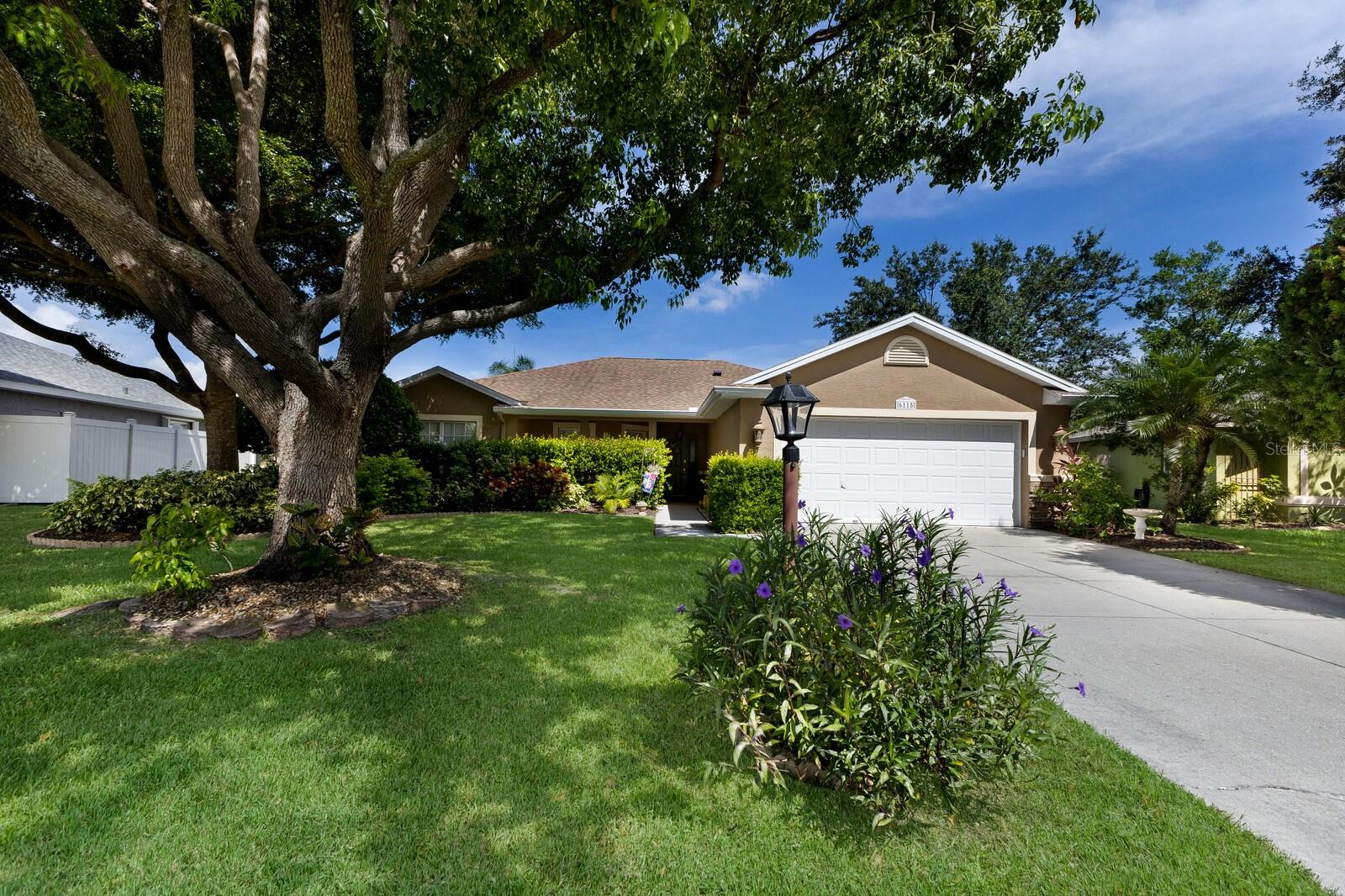 This one is worth putting at the top of your search list, it exudes character and charm missing in many new builds today. A big beautiful shade tree, stone front and a covered front porch welcome you home. The open floorplan lives large for its square footage, filled with natural light. A stone fireplace creates a cozy backdrop for the main living area. The bright and breezy kitchen is perfect for cooking and conversation. A covered screened-in back porch overlooks a tranquil pond with lush landscaping creating a sense of privacy. Also features a newer roof (2017) and AC (2020). Located in a quiet, deed-restricted community with very low HOA fees and no CDD fees, with convenient access to I-75, 301, shopping, dining, and schools.