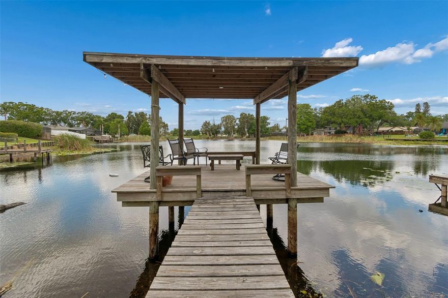 Welcome to Lake George! Nestled on a spacious corner lot just shy of a quarter acre, this 3 bed, 2 bath lakefront home blends thoughtful updates with the charm of waterfront living. Picture mornings beneath mature oak trees, coffee in hand, with peaceful views of the water setting the tone for the day. Recent improvements include a roof (2021), most windows (2021), and exterior paint (2020), offering both peace of mind and curb appeal. Inside, the kitchen features granite countertops, a new range hood vent, and a great open concept for easy entertaining. The existing concrete floors provide a blank canvas, giving the next owner the freedom to choose finishes that match their own style and vision. Both bathrooms have been beautifully updated with modern quartz finishes (2025). French doors bring in beautiful natural light and open to the home’s best view—Lake George.
In the fenced backyard, you’ll find your very own greenhouse with its own irrigation system, offering a unique space for gardening enthusiasts or additional storage. A newly fenced side yard (2025) sits separate from the open lakefront backyard, offering a great option for pet owners or anyone looking for a more contained outdoor space without direct access to the water. Additional highlights include a two-car garage, A/C unit (2014), and a circular driveway for easy access. Listed at appraised value (November 2025). Conveniently located near Dale Mabry Highway, you’ll have easy access to a variety of local shops, dining options, and everyday essentials, all while enjoying the calm and comfort of lakefront living—come see how life on a lake could truly feel.