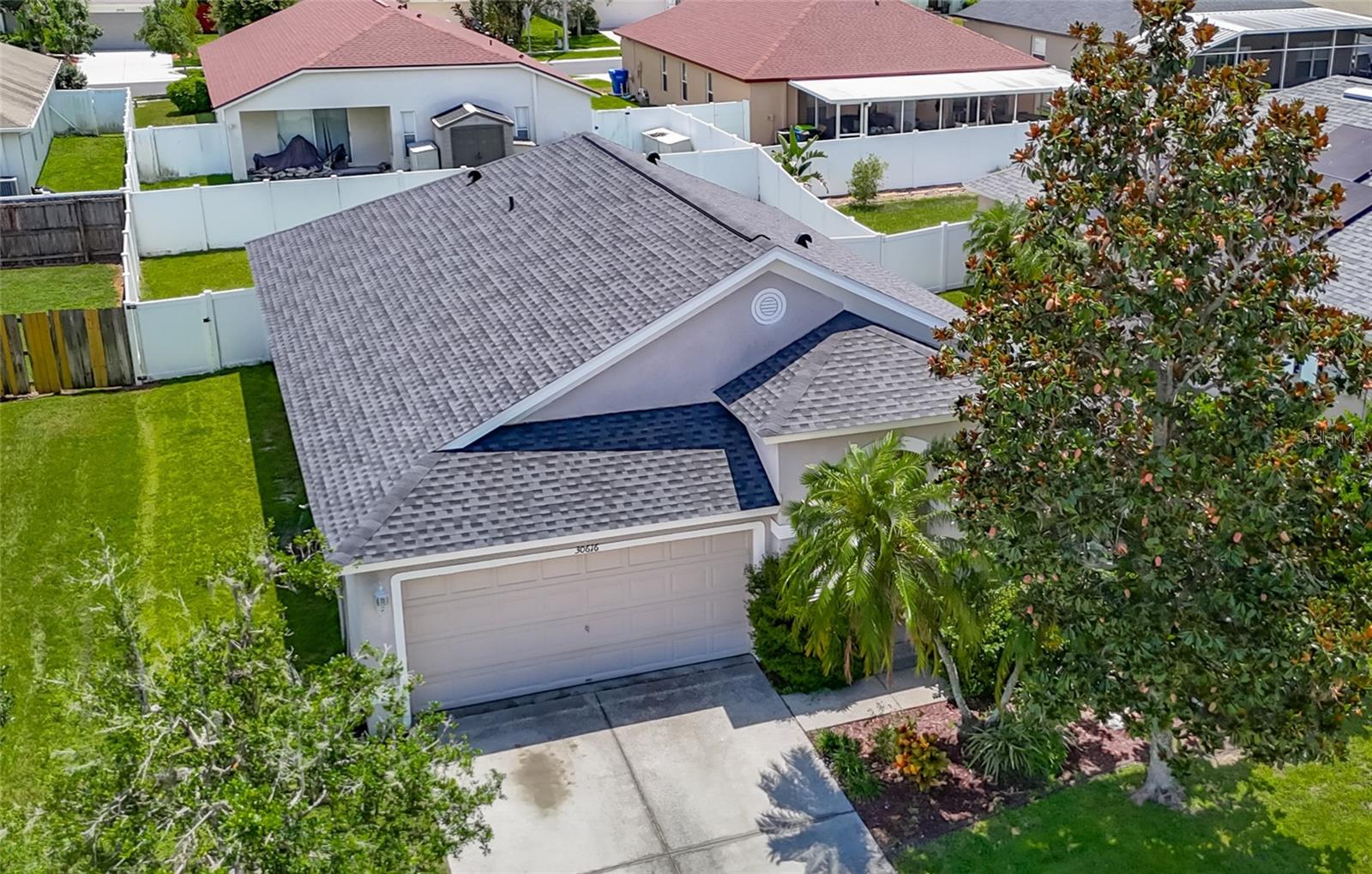 Welcome to this inviting 4 bedroom, 2 bath residence located in the sought after community of Meadow Pointe in Wesley Chapel. Nestled in the peaceful gated village of Ammanford, this home lives much bigger than its 1956 square feet. Fully fenced and Low HOA plus a new roof!(April ’25). Step inside to discover a light filled open floor plan, vaulted ceilings, and plantation shutters, featuring a spacious living area ideal for entertaining or relaxing with loved ones. The kitchen boasts ample cabinetry, generous counter space, and a breakfast nook overlooking the backyard, an ideal spot for your morning coffee. The spacious primary suite offers a private retreat with a walk in closet and a full en-suite bathroom with split vanities with a makeup/vanity space. Three additional bedrooms provide plenty of flexibility for guests, a home office, or playroom. Enjoy the Florida sunshine in your fenced backyard, perfect for outdoor gatherings, gardening, or simply unwinding. Additional highlights include a two car garage, laundry area, and energy efficient features throughout. Located just minutes from top rated schools, Prime Outlets and The Shoppes of Wiregrass for all your shopping and dining pleasures, BayCare and AdventHealth hospitals for your medical needs and easy highway access. This home brings the best of Wesley Chapel right to your doorstep. Don’t miss the opportunity to make 30616 Lanesborough Circle your new address, schedule your private tour today!