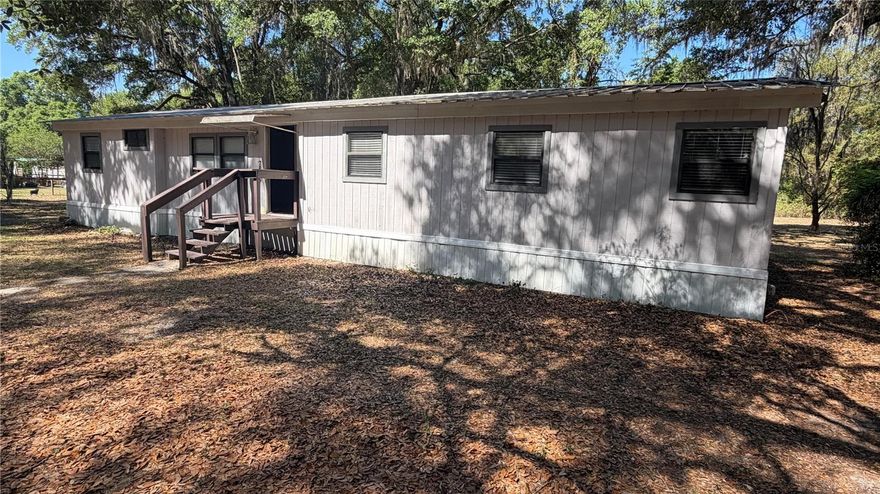 This 3-bedroom, 2-bathroom double-wide home offers a spacious 1,423 square foot layout on a cleared 1.01-acre lot. Featuring high ceilings, vinyl flooring, large laundry room, eat in kitchen, bonus room for an office, double primary bedroom and a Florida room for extra living space so as the interior provides a comfortable and modern feel. The exterior is built for durability with HardiPlank type siding and a metal roof. The lot features a large barn style shed that could be finished into a guest house, art studio, music room, etc. Property has citrus trees, mature grape vines, large live oaks for plenty of shade. 
Just minutes to 6000 acre Santa Fe with 4 public boat ramps and parks. Home is Located in Lake Bonnet Estates, you are in the heart of Florida's lake country, surrounded by numerous recreational lakes for boating, fishing, and outdoor enjoyment  Enjoy over an acre of cleared, wire-fenced land with no HOA fees or restrictions.
This property is perfectly situated in Melrose, offering a convenient commute between the city amenities of Gainesville and the historic charm of Palatka.