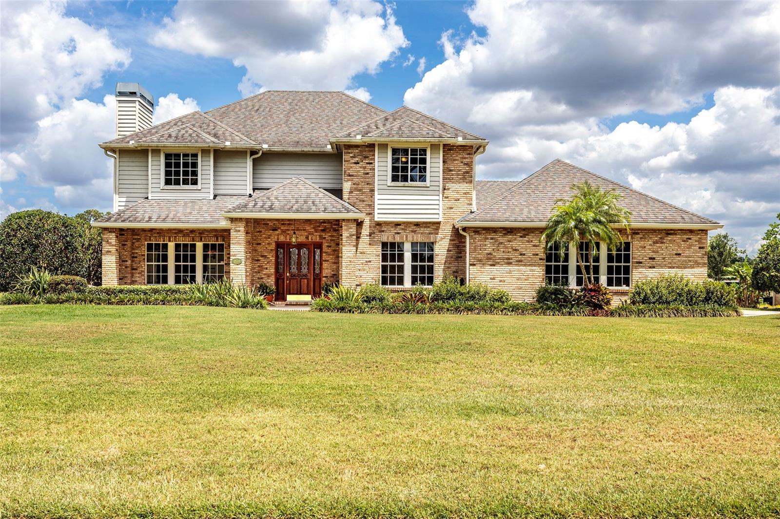 Beautiful custom built 4/3 home on lagoon to the Harris Chain of Lakes with it's own dock & boathouse waiting for you.
Within 1 mile of Deer Island Golf course without HOA or HOA Fees. This home has plenty of privacy with a parklike setting in the front yard & stunning water views in the backyard. The 1 acre property with it's lush landscaping along with it's many fruit trees offers a tropical paradise. Fish from the dock & boathouse or just sit & watch all of the wildlife from your backyard. This is truly a fisherman's or bird watcher's paradise. As you enter the home you'll see the elegant, curved staircase taking you upstairs to the huge master suite. The master bath has a whirlpool garden tub with surrounding windows that provide stunning views of the sparkling lagoon. Completing the second floor are two large bedrooms & another full bath. The Main floor consists of a formal living room with a wood burning fireplace, formal dining room, kitchen with breakfast nook leading to family room with eye-catching water views. The 4th bedroom along with the 3rd bath, are also on the main floor. So many upgrades in this home here are just a few a 3 car oversized garage with a separate, air conditioned workshop, two zone heat pump HVAC, ADT security system, central vacuum system. Come take a look!
