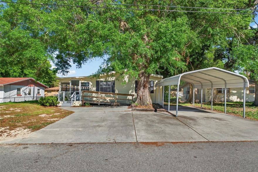 One or more photo(s) has been virtually staged. LOOKING FOR SPACE INSIDE AND OUTSIDE?  This 3BR/2BA doublewide mfg home has a huge living room in addition to a separate dining room , numerous storage closets, an inside laundry room PLUS a  47'x11' enclosed porch PLUS an over 500 sq ft block workshop/storage building with electric. There is brand new LVP just installed in the living room, dining room and guest bath in addition to a new HVAC unit and entire new septic system in 2025!  There is a carport for vehicle cover, driveway parking and an access ramp too. Located within five minutes to the current and also the coming soon Mariana Publix, the Lake Mariana boat ramp and to the renowned Auburndale downtown and city park. Auburndale has the Lake Myrtle Sports Complex, the new Lake Ariana Park complex on the shores of Lake Ariana with lake access for boating and fishing and community events. With easy access to major roads for travel, dining, medical and shopping this is quite a value for an Auburndale location!