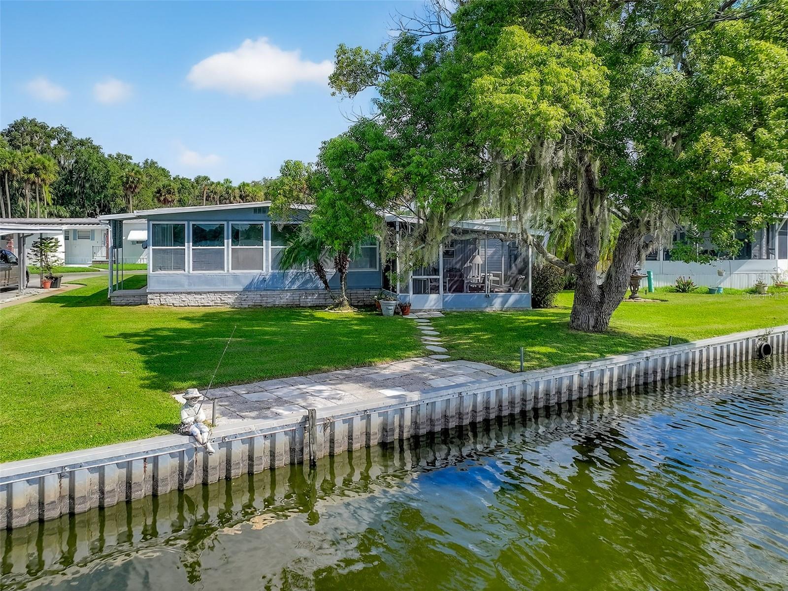 Lakefront home for sale on beautiful Trout Lake in Eustis FL with amazing panoramic lake views! Affordable living right on a beautiful sports and fishing lake with 65 feet of lake frontage in the desirable Country Club Manor, a co-op 55+ community with great amenities like- clubhouse- shuffleboard- swimming pool and more! Water, trash and sewer are also included in the $231. monthly co-op fee. 2 bedrooms and 2 full baths, 1,104 Sq Ft and total square feet under air along with a very large screened in patio area with lake views, giving a total covered area of 1790 square feet. The family/dining rooms plus the screened patio/lanai overlook the lake. Open floor plan with Kitchen, living room & family room combination. Community boat ramp, heated lakefront POOL and fishing pier. Only minutes to downtown Eustis with great restaurants and shopping and Mt. Dora is just a short drive. This gem would make a perfect place for snowbirds or year round living in Central Florida. Make plans to tour this lovely lakefront home today!