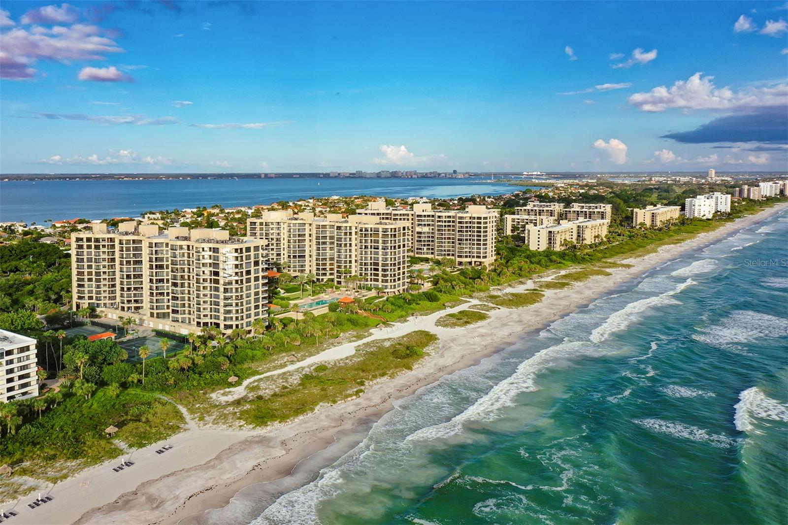 Welcome to this spectacular 6th floor redesigned Dover floor plan located in the south building of the sensational Gulfront Water Club complex on south Longboat Key. This custom three bedroom condo has been remodeled and enhanced by the use of the finest high-end designer finishes. Your private elevator opens directly into the foyer and showcases the beautiful Sarasota Bay and the Sarasota skyline through floor to ceiling glass. New twenty-four inch porcelain tile runs throughout the main living area which is enhanced by spectacular new ceilings lights. The remolded kitchen is now open to the main family living area. Other new kitchen features include Graber cabinets, Ceasar stone quartz countertops plus a stunning glass backsplash. New appliances include a Kitchenaid stovetop and new hood, microwave, Bosch dishwasher and Sub-zero refrigerator. David Trubridge pendants from New Zealand are an added beautiful designer feature. The remodeled floorplan includes an added third bedroom and the existing en suite second bedroom bath has been totally redone. Both guest suites have stunning Bay views and a terrace. The spacious master suite is completely private with a large walk-in closet and has sliding glass doors leading to a private terrace with views of the Gulf of Mexico. The southern exposure of this home bathes it in sunlight and stunning sunrises are breathtaking along with bright cityscape lights at night that are enchanting across the Sarasota Bay to the downtown Sarasota city skyline. The Water Club is a luxurious resort style complex on the beautiful sandy beach and azure waters of the Gulf of Mexico. The Water Club amenities include four tennis courts, a centrally located large pool and spa and a 24 hour staff plus gated access. The 17,000 sq.ft clubhouse features a spa and gym area separate for men and women plus a library and a catering kitchen and ballroom. The Water Club is conveniently located just minutes from award winning restaurants plus Publix and CVS, St Armands Circle, downtown Sarasota and the Longboat Key Club for golf, tennis and restaurants are also nearby.