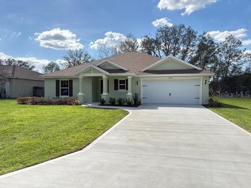 NEW HOME-Marion Oaks unit 7- Home sits on .25 Acres. Large back yard. The 3-bedroom, 2 full bath, 2 car garage home offers 1,611 living sq. ft. and 2,277 total sq ft.  This home has a large separate dining room with a butler pantry that leads to the Kitchen/Great room.  Luxury vinyl plank flooring in all of the home except for the bedrooms which are carpeted.  Lots of windows to let in natural light.  There is a covered lanai.  Yard is fully sodded and landscaped with an irrigation system.  Home comes with a 10-yr structural warranty.  The garage offers pull down attic stairs and a garage door opener.  The guest bathroom features a tiled shower and granite countertops.  The Kitchen features an island and butler pantry.  The owner suite gives a cozy feel with a tiled shower and dual sinks with walk in closet. This home is ready for its new owners!