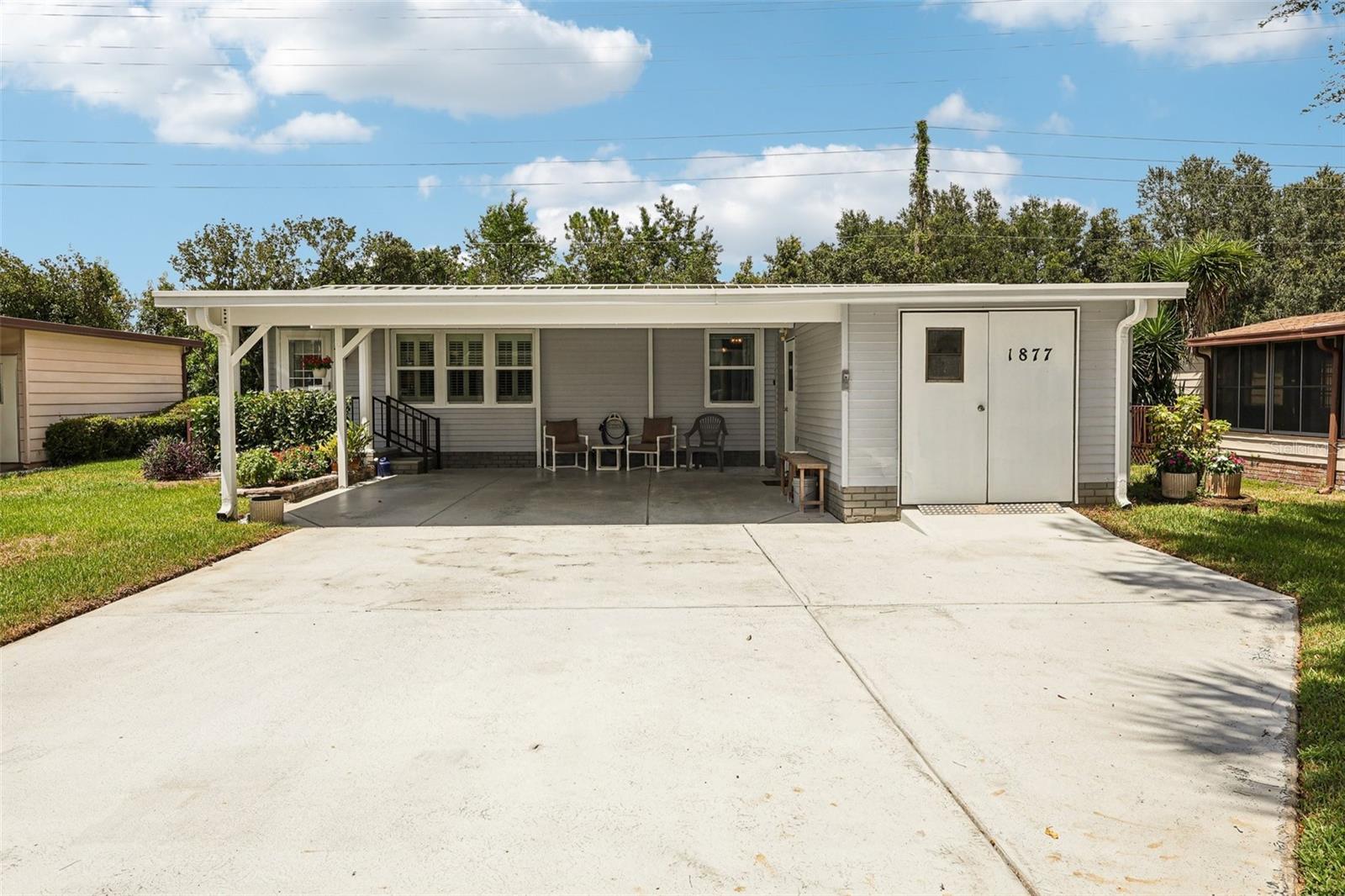 NO BOND! This beautifully maintained 2BR/2BA home offers a bright open layout, vaulted ceilings, and stylish upgrades throughout. Step into tile and laminate flooring, plantation shutters, and an updated kitchen and cabinetry, real Tiffany light fixture, newer stainless appliances, and a breakfast bar. The Florida Room is under heat and air with glass windows, leading to a peaceful deck—perfect for relaxing or entertaining. Enjoy added privacy with no rear neighbors and the occasional visit from a friendly horse! The primary suite features dual closets and a large tiled step-in shower. Additional highlights include inside laundry, updated windows, double carport, golf cart garage with workshop, and a 2014 Gas Yamaha golf cart INCLUDED