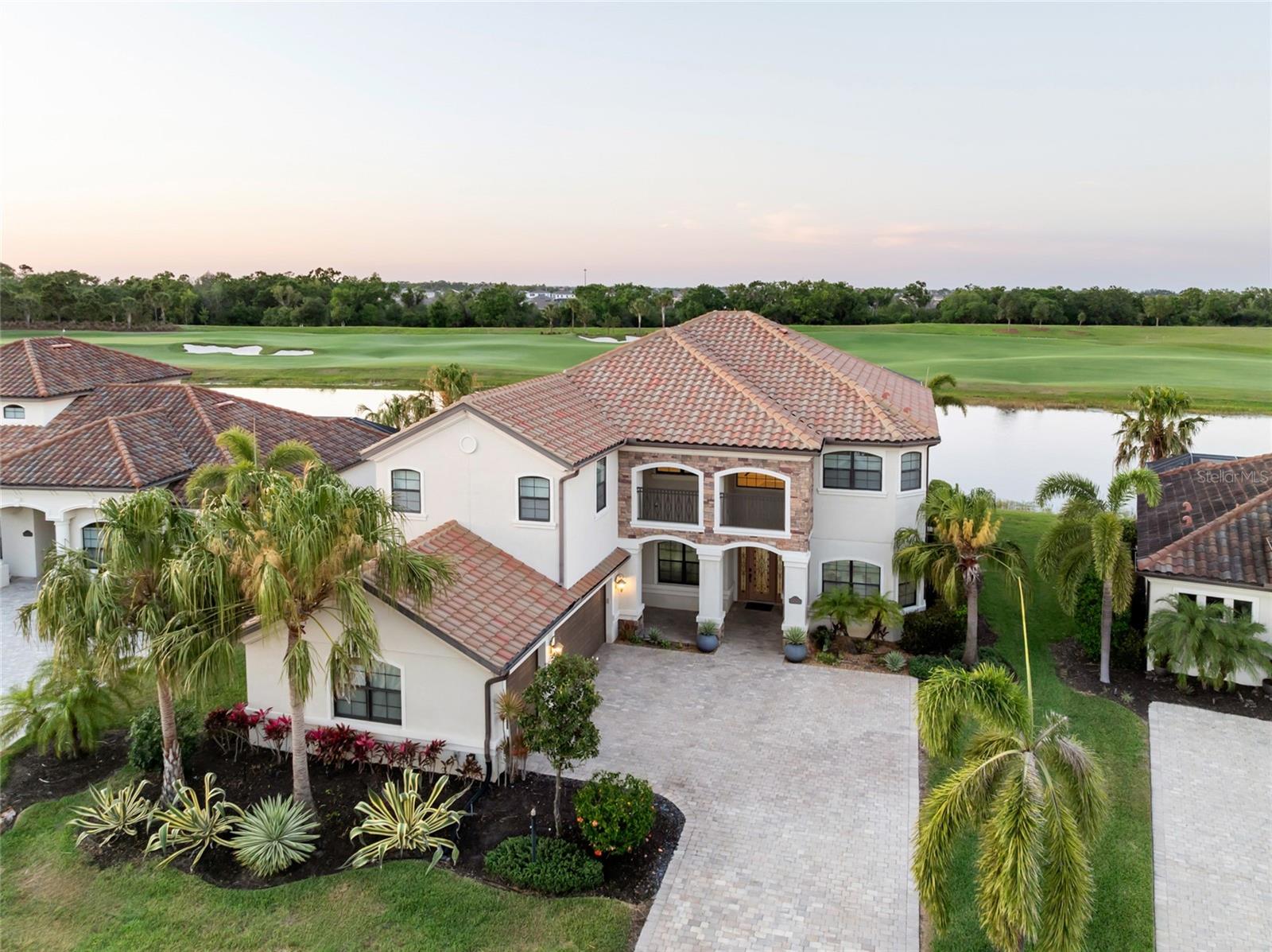 Spectacular lake and golf course views from this expansive residence in the gated resort style community of Lakewood National! You will be captivated as soon as you pull up to this impressive pool home. The excellent use of space creates a tranquil retreat and is also an ideal place for entertaining. The chef of the home will enjoy cooking in the open concept kitchen which is equipped with a gas cooktop, dual ovens, granite counters, tile backsplash and breakfast nook. A row of sliding glass doors off the kitchen and family room open to a 2 story screened lanai with pool and outdoor kitchen, offering generous space and privacy for outdoor living. Enjoy a glass of wine poolside or unwind in the heated spa while taking in gorgeous sunsets. Rounding out the 1st floor is a formal living room, dining room and guest bedroom with adjacent full bath which is easily accessed from the pool. The second floor, accessible via dual staircases, features a loft area which is the perfect space for a playroom, office, or craft room. The master suite is a welcoming retreat with a screened balcony overlooking the pool, lake and golf course, his and her walk-in closets, and a spa-like ensuite with dual vanities, soaking tub and walk-in shower. This home features a large 2nd suite offering guests space and privacy. Two additional bedrooms on the 2nd floor also have access to the large balcony within the screened lanai. Enjoy a maintenance-free Florida lifestyle and an abundance of amenities including a 36-hole PGA Arnold Palmer designed golf course, member programming, priority tee times, world class professional golf instructors, state-of-the-art clubhouse, zero entry heated resort-style pool, poolside cafe and tiki bar, elegant dining, full service spa, fitness center including group classes, on-site TPI Certified Personal Trainer, eight lighted Har-Tru tennis courts, pickleball and bocce. When exiting the attractive side load 3-car garage, you will enjoy easy access to everything from family-friendly and gourmet restaurants, exceptional shopping and entertainment, award winning beaches, I-75, UTC Mall and Downtown Sarasota. Is this home your perfect match? Book your showing today!