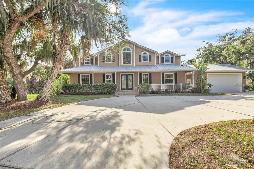 Tucked away on 13 wooded acres, this charming two-story Southern-style residence offers three bedrooms and three bathrooms in a peaceful, private setting—ideal for both comfortable living and versatile land use. The cross-fenced property, complete with multiple gates, showcases open pasture, towering oaks draped in Spanish moss, and a scenic pond, making it perfectly suited for equestrian pursuits, livestock, or a private homestead lifestyle. A graceful, curved driveway leads to the home’s classic façade, highlighted by an expansive covered front porch and a detached two-car garage. Outdoor living is exceptional, featuring a heated pool for year-round enjoyment, along with a substantial 3,240-square-foot barn, additional outbuildings, and a thoughtfully designed acreage layout that delivers outstanding functionality. Extensive upgrades provide peace of mind and modern convenience, including a metal roof, impact windows with storm shutters, a 27kW Generac generator, a 500-gallon buried propane tank, a whole-house reverse osmosis system, and an A/C system replaced in 2021. Inside, the expansive great room flows seamlessly into the dining area and kitchen, anchored by durable tile flooring that enhances the home’s light and airy ambiance. A dramatic two-story ceiling and an open wood staircase with classic railing create a striking first impression. Rich wood trim and plantation shutters add warmth and character, while large glass doors flood the space with natural light and provide effortless access to the outdoors. Graceful archways define each living space while preserving an open, cohesive flow—ideal for both everyday living and entertaining. The beautifully appointed chef’s kitchen serves as the heart of the home, overlooking the main living area to keep everyone connected. Custom raised-panel wood cabinetry with crown molding offers abundant storage, complemented by polished granite countertops and a coordinating tile backsplash. A professional Wolf gas range paired with a sleek stainless-steel hood creates a standout focal point, while the spacious island with bar seating is perfect for casual dining and gathering. The first-floor owner’s suite provides a private retreat, featuring a custom walk-in closet, jetted soaking tub, Roman shower, dual granite vanities, and a separate water closet. The second floor opens to an expansive and versatile loft area, ideal for a media room, home office, studio, or additional living space. Filled with natural light from arched windows and enhanced by vaulted ceilings and track lighting, the loft features wide-plank flooring and an open railing that overlooks the main living area below, creating an airy, connected feel. Extensive custom built-in cabinetry provides abundant storage and generous work surfaces. This level is flanked by two large bedrooms and complemented by a full guest bath, making it ideal for family living or guest accommodations. Altogether, this exceptional property offers a rare blend of privacy, functionality, and Southern charm, with thoughtfully upgraded systems and versatile spaces designed for both everyday living and long-term enjoyment. Whether you envision a working homestead, or simply a serene retreat surrounded by nature, this estate delivers space, comfort, and timeless appeal in a truly picturesque setting. **PLEASE ENJOY THE 3D INTERACTIVE VIRTUAL TOUR ASSOCIATED WITH THIS LISTING**