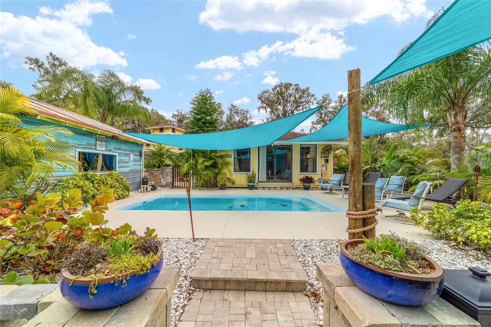 THIS PLACE WOULD MAKE A GREAT Air B&B!!!! Nestled on a sprawling 5.29 acres, this extraordinary property presents a unique opportunity for a discerning buyer. The centerpiece is a charming three story home, boasting three bedrooms and two bathrooms, complete with a two-car garage. What makes this offering truly exceptional is its dual address- 19785 SE 156th Street and 19855 SE Highway 42- encompassing six distinct parcels and three wells. This allows for incredible flexibility whether you envision building a private compound or exploring the potential of selling off individual parcels. The backyard is an entertainer's paradise, a meticulously landscaped oasis featuring a pool house, an inviting inground pool, a fun tiki bar perfect for grilling, and a relaxing outdoor cabana. Adding to the versatility is a large workshop, situated within the A1 zoning, while the home and surrounding parcels enjoy R4 zoning. Privacy is paramount with a gated driveway securing this haven, located a mere quarter mile from Ocklawaha River, providing access to the chain of lakes, and only 12 miles from The Villages. Furthermore, the property includes two camper hookups, a 50 amp and a 30-amp, each with a dedicated water supply. This one of-a-kind property offers endless possibilities, and a showing requires a one hour notice due to the presence of a guard dog that must be secured.