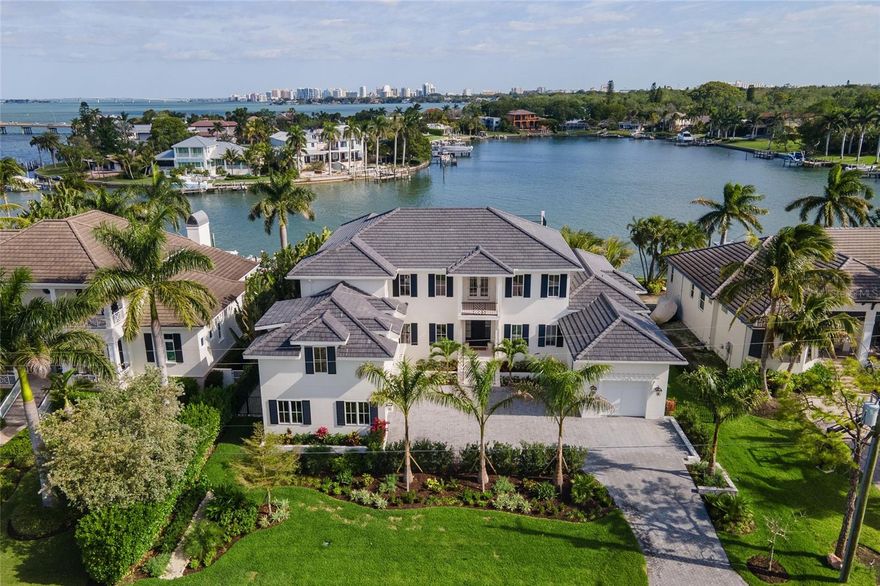 Newly completed home custom built by award winning builder, NC Ferguson Construction. This coastal residence captivates with its impeccably designed décor and outdoor living spaces in a scenic waterfront setting only seconds to the open waters of Sarasota Bay. Located West of Trail, Tangier Way is a quiet street situated centrally to Siesta Key, Southside Village, A-rated schools, and downtown Sarasota. The just under 6,000 square foot home is comprised of state-of-the-art building techniques and nautically-inspired interior details including hardwood floors and a light, airy aesthetic. The thoughtful floorplan begins in the gracious living room where 10’ sliding glass doors overlooking the water makes receiving guests an art. Interior highlights include the formal dining room, gourmet kitchen with eat-in cafe, and family room – centered around beautiful Bay views. Five en-suite bedrooms, private office and a bonus room ensure space for everyone. Two laundry rooms, one upstairs and down, are a true luxury of time and space. Add an elevator or generator for your convenience. Enjoy inspiring Florida evenings as you dine in the outdoor covered entertaining area or savor water views spanning Siesta Key to downtown on the rooftop deck. Every day will feel like a vacation as you soak in your heated pool and spa. A new seawall and cap complement the boating experience. Custom built by award winning luxury home builder, NC Ferguson Construction.