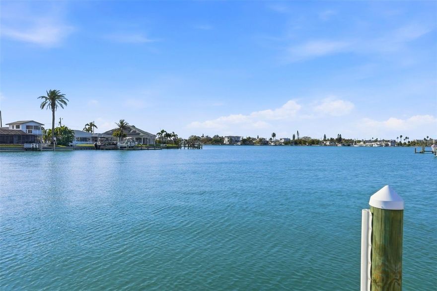 Welcome to this exceptional waterfront luxury residence in the heart of highly sought after St. Pete Beach, where modern upgrades, coastal elegance, and premier Florida lifestyle converge. This beautifully updated 4 bedroom, 2 bath single story waterfront pool home is perfectly positioned just three blocks from the world renowned Gulf beaches, offering the rare combination of deep water access, boating convenience, and walkable beach living. Designed with both sophistication and functionality in mind, the interior showcases stunning porcelain tile flooring throughout, creating a seamless, durable, and elegant living environment. The chef’s kitchen features upgraded Bespoke appliances including a sleek matte cooktop, wine refrigerator, and modern quartz countertops ideal for entertaining and everyday living. The spacious open living area is enhanced by a contemporary electric fireplace, creating a warm and inviting focal point. The home is thoughtfully appointed with premium upgrades, including hurricane screens for peace of mind, a smart Ecobee thermostat for energy efficiency and climate control, plantation shutters, and sliding glass doors with built-in blinds providing effortless indoor/outdoor living, privacy, and convenience. Step outside to the private tropical waterfront oasis designed for the ultimate Florida lifestyle. The resort style pool features a relaxing sun shelf perfect for lounging in the Florida sunshine. The fully equipped pergola creates an extraordinary outdoor living space complete with full electrical service and two mounted televisions, ideal for year round entertaining. The property also features low maintenance AstroTurf in both the front and backyard, delivering lush green landscaping without the upkeep. Boating enthusiasts will appreciate the composite dock and 13,000-pound boat lift, providing convenient access to the Intracoastal or the Gulf making this property ideal for boating, fishing, and sunset cruising. A deep water slip adjacent to the existing dock can accommodate a boat up to 50 feet. Exceptional curb appeal is highlighted by a pavered circular driveway offering ample parking. This prime St. Pete Beach location provides easy access to waterfront recreation, sugar sand beaches, waterfront dining, and coastal amenities, while also offering close proximity to the vibrant downtown St. Petersburg district featuring award winning restaurants, boutique shopping, art galleries, waterfront parks, and renowned museums.  A rare opportunity to own a fully upgraded coastal retreat combining modern design, premium amenities, boating access, beach proximity, and the very best of Florida waterfront living.