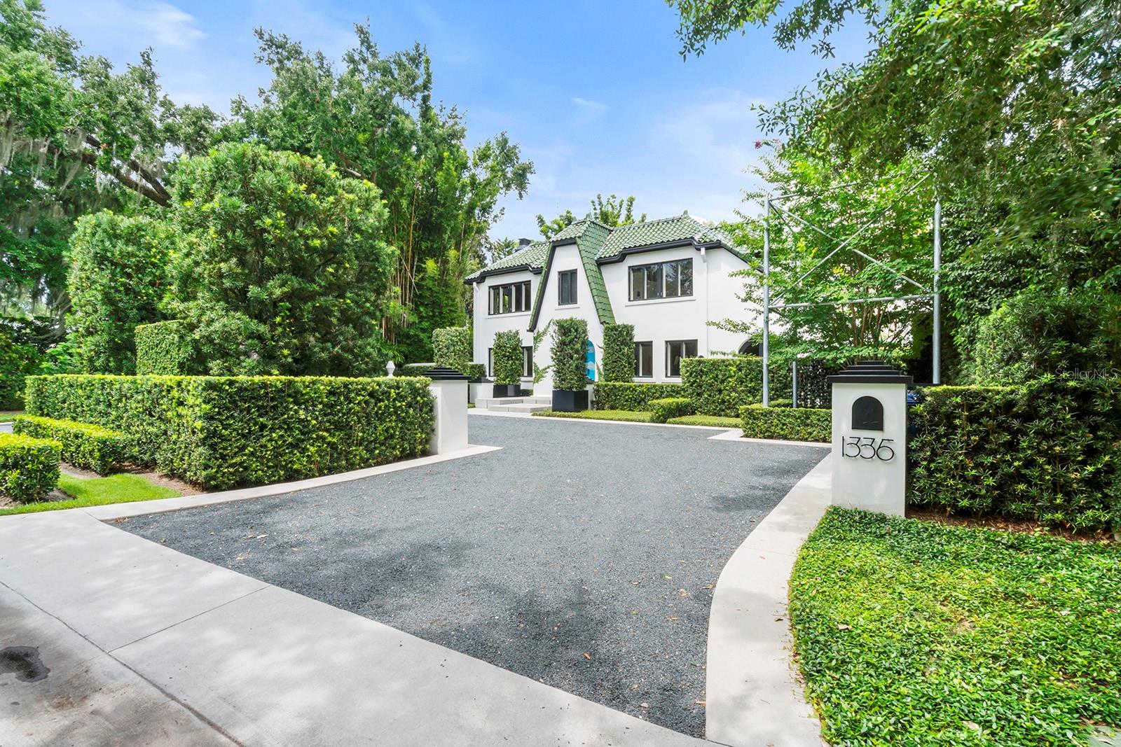 Steeped in history and masterfully reimagined, this 1926 Winter Park estate blends architectural provenance with modern refinement. Thoughtfully restored by E2 Homes, the residence honors its past while offering contemporary sophistication. Unlike many historic properties, it is free from preservation restrictions, allowing for seamless enhancements. On the shores of Lake Virginia along the desirable Winter Park Chain of Lakes, this 3,181-square-foot estate features four bedrooms, three full baths and two half baths, with three bedrooms in main house plus detached one-bedroom guest cottage. The second-floor primary suite is a private retreat with a Juliet balcony, dual closets and an elegantly appointed bath with an expansive dual-sink vanity, a separate water closet, and a washroom with a shower-tub combination. A Jack and Jill bath, adorned with Maharam wallpaper, serves the additional upstairs bedrooms. The Poliform TWELVE kitchen showcases European craftsmanship with Gaggenau and Sub-Zero appliances, sleek Italian cabinetry, and natural basalt countertops. The formal dining room, framed by arched windows and French doors, opens to a vine-covered courtyard, while the sunroom offers uninterrupted lake views. A fireplace in the living room, flanked by custom built-ins, adds warmth to the home’s contemporary aesthetic. Beyond its striking interiors, the estate is an architectural rarity, featuring original woodwork by Gene Leedy, a key figure in the Sarasota School of Architecture. The home is crowned with sought-after Ludowici-Celadon Imperial roof tiles. Poliform built-ins extend throughout, including a dedicated upstairs office/library. An integration of art and architecture, the property features site-specific installations by acclaimed artist Matt Olson. His No Separation project finds a compelling continuation here, with a sculptural installation of galvanized steel surrounding a crepe myrtle, accompanied by a matching bike rack. The entryway, designed by Olson’s firm OOIEE and inspired by Sol LeWitt, makes a striking first impression. Designed for seamless indoor-outdoor living, the estate’s exterior spaces are as refined as its interiors. A covered deck overlooks a heated saltwater pool and spa, while a custom cedar hot tub blends into the landscape. A wood-clad pergola shelters the outdoor kitchen, featuring a Röshults system with a professional-grade grill, sink and storage. The boathouse includes a partial bath, creating a waterfront sanctuary. A Sonos-integrated sound system extends from the main house to the patio, guesthouse and boathouse, ensuring a seamless sensory experience. The detached guesthouse is a private retreat with a full bedroom, bath, kitchenette and Poliform built-ins. Floor-to-ceiling windows frame manicured grounds and lake views, while a private covered porch provides a tranquil space for relaxation. Every detail has been meticulously curated, from designer lighting to motorized roller shades and a wood-burning fireplace anchoring the living room. A private wine library enhances the home’s sophisticated appeal. Meticulously maintained by E2 Concierge services, the residence undergoes routine wellness checks and meticulous upkeep. A distinctive home of this caliber is rarely available, a residence where history, architecture and art converge in harmony. This is a once-in-a-lifetime opportunity to own one of Winter Park’s architecturally and artistically significant properties.