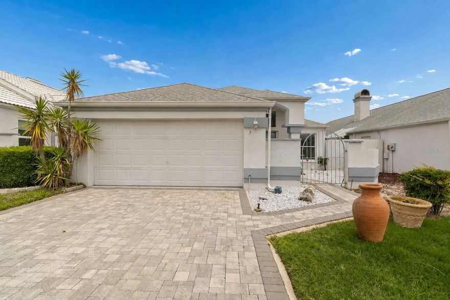 If maintenance-free Florida living is the goal, this beautifully updated villa in the deed-restricted Gardens of Seven Hills delivers comfort, style, and convenience in one thoughtfully designed package. From the paver-lined driveway and private gated courtyard entry to the clean modern finishes, this home offers standout curb appeal and an inviting sense of privacy from the moment you arrive.

Inside, soaring vaulted ceilings and an expansive open-concept layout create a bright, airy atmosphere filled with natural light. Rich luxury vinyl flooring flows throughout the main living spaces, complemented by soft contemporary tones, updated lighting, and oversized gathering areas designed for both everyday living and entertaining. The spacious living and dining areas blend seamlessly together, while a charming dry bar adds functionality and the perfect setup for hosting family and friends.

The kitchen has been tastefully refreshed with white shaker-style cabinetry, quartz countertops, stainless steel appliances, recessed lighting, a modern vent hood, tiled backsplash, abundant cabinet storage, and a generous breakfast bar overlooking the main living spaces. Multiple sliding glass doors and oversized windows create effortless indoor-outdoor flow and enhance the home’s bright, welcoming feel.

The spacious primary suite serves as a relaxing retreat with private access to the enclosed Florida room, a large walk-in closet, and an ensuite bathroom featuring an oversized vanity, garden tub, and separate shower. The split-bedroom floor plan provides added privacy for guests or flexible space for a home office setup. Updated bathrooms, interior laundry with storage cabinetry, and modern finishes throughout further enhance the home’s move-in-ready appeal.

One of the home’s most unique features is the oversized wrap-around screened Florida room and courtyard-style layout, creating a peaceful outdoor living space that can be enjoyed year-round. Ceiling fans help keep the space comfortable, while the fenced backyard offers room to personalize and enjoy Florida’s outdoor lifestyle.

Located in the highly desirable Seven Hills area, this home is close to shopping, dining, medical plazas, golf courses, parks, and everyday conveniences. Veterans Memorial Park with its playground and lighted fitness trail is nearby, while the natural beauty of Weeki Wachee Springs State Park, Pine Island, Roger’s Park, and the Gulf Coast are all within easy reach. The Suncoast Parkway is just minutes away, providing convenient access to Tampa, Clearwater, St. Petersburg, Orlando attractions, and beyond.

This is the kind of home that blends low-maintenance living, thoughtful updates, and spacious indoor-outdoor design into a lifestyle that feels comfortable, polished, and distinctly Florida.