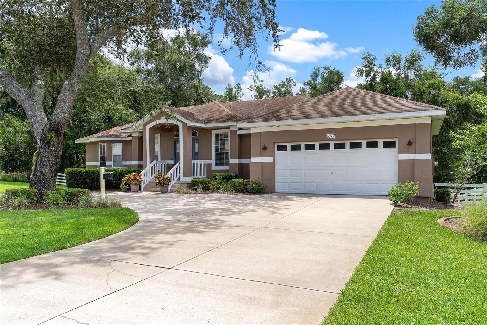 Fruitland Park at it's finest! Welcome to this beautifully maintained home located in the sought-after Spring Lake Pines neighborhood of Fruitland Park. Sitting on a generous 0.82-acre lot, this 3-bedroom, 2.5-bath home offers over 2,500 square feet of living space and a thoughtful split-level layout. The main floor features the master suite, kitchen, formal dining room, 1/2 bathroom, and living area. The kitchen offers upgraded LG stainless steel appliances including a double oven, a center island, and a spacious pantry. The formal dining room is perfect for entertaining, and a convenient half bath is available for guests. Flooring throughout the home includes tile and wood. The master suite boasts tray ceilings, two closets, and an en-suite bath with dual vanities, a garden tub, and separate shower. Downstairs you'll find two spacious guest bedrooms, several bonus areas ideal for offices or study nooks, and a second living area with sliding glass doors that open to a paver patio featuring a built-in fire pit. Additional features include a circular driveway, a two-car garage with built-in cabinetry, a large laundry room with storage closet, Nest thermostats with zoned controls, and a 2019 A/C system with warranty. The fully fenced backyard offers privacy and space for outdoor enjoyment. The upstairs balcony provides a relaxing view of the backyard and entertaining patio below. This home offers a perfect blend of space, comfort, and convenience in a peaceful, established neighborhood.