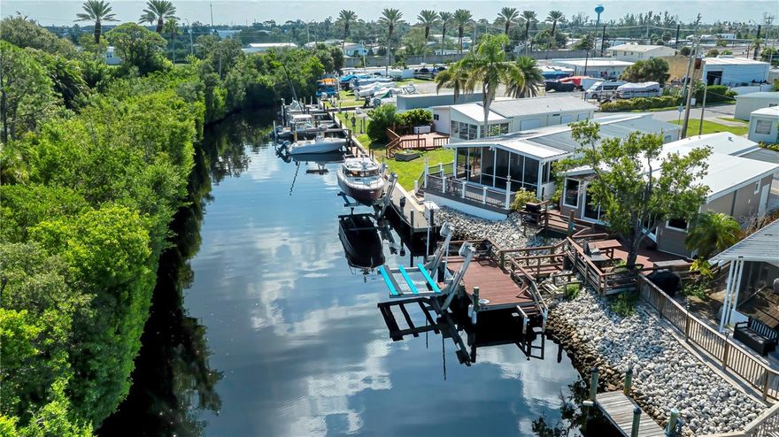 If you have been looking for affordable waterfront living near the island of Venice then look no further! Harbor Lights is a highly sought-after 55+ co-op community located directly on the Intracoastal Waterway next to Dockside Grill and north bridge on the island of Venice. This adorable deep water canal 3-bedroom, 2-bathroom mobile home offers the perfect blend of laid-back Florida lifestyle and boater’s paradise. You will find kitchen with granite counters and stainless appliances, vinyl flooring, dinette with views of the deep water canal. Step outside to your large back deck overlooking a deep-water canal with no fixed bridges to the Gulf, a true dream for boaters. Your private dock features electric, water, and a 7,000 lb. boat lift, making this the ideal home for your boat. You’ll appreciate the unbeatable location, walk to historic downtown Venice to enjoy shopping, dining, and the vibrant island lifestyle. Harbor Lights residents enjoy amenities including a community pool, tennis court, and shuffleboard courts. Just minutes away are Venice’s pristine beaches, fabulous restaurants, and boutique shops, ensuring every day feels like vacation. Don’t miss this rare opportunity to own affordable waterfront property in one of Venice’s most desirable 55+ communities. This is Florida living at its best!